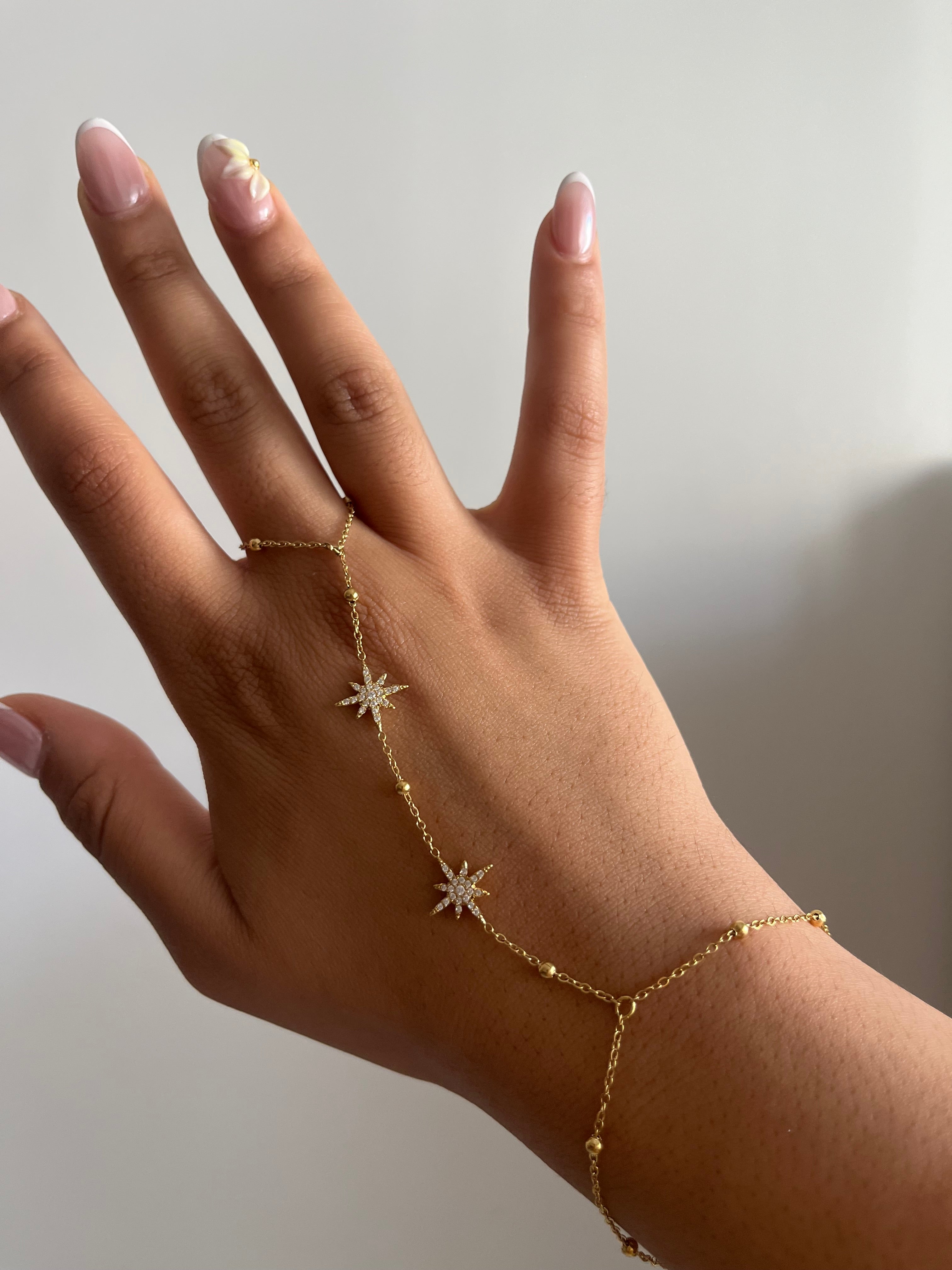 Chaîne de main Météores en acier inoxydable brillant avec des motifs d'étoiles délicats portée sur la main Ordiajade