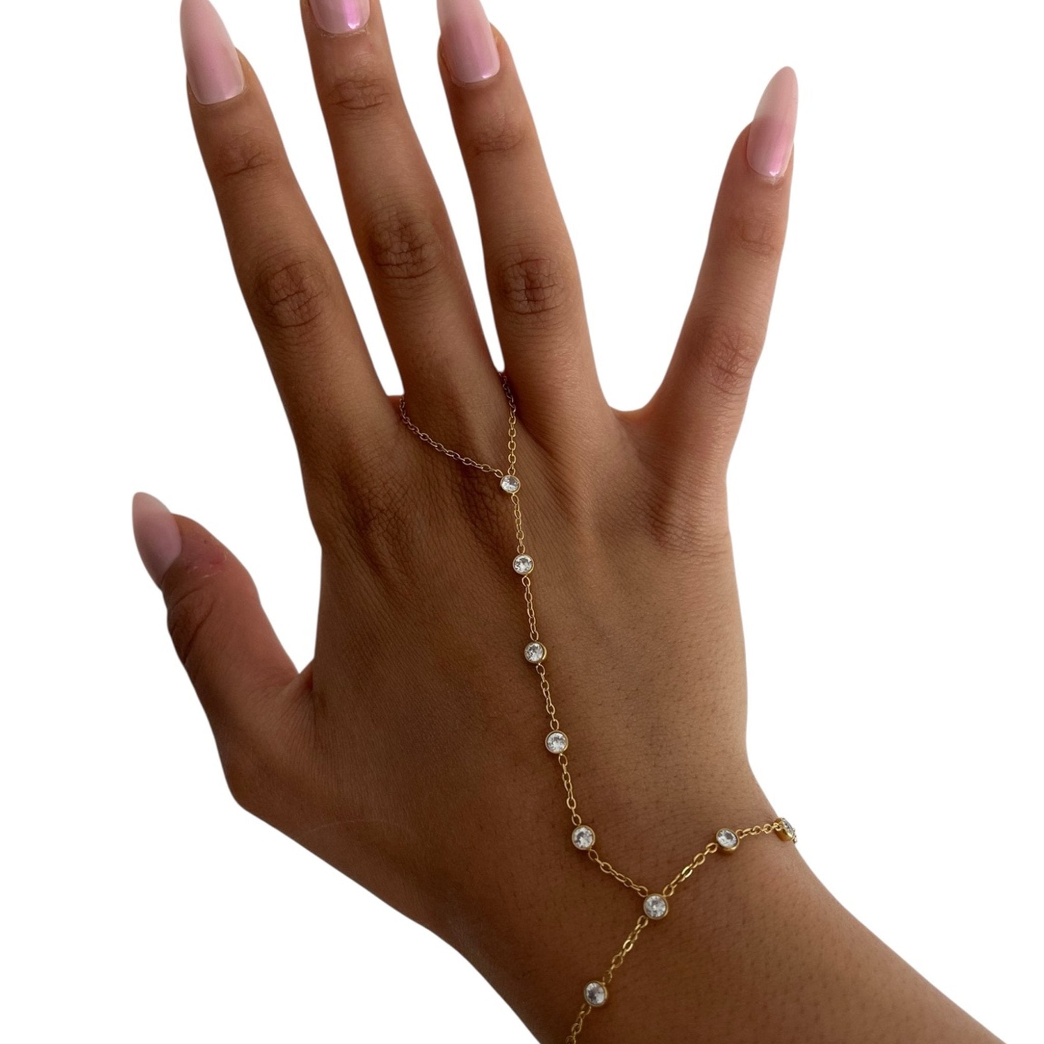 Chaîne de main fine en acier inoxydable doré avec strass étincelants portée sur une main.
