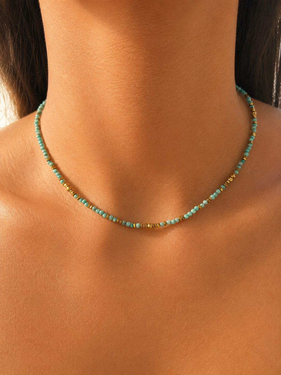 Collier fin Divina en acier inoxydable doré composé d'un rang de petites pierres naturelles turquoises porté au cou - Ordiajade