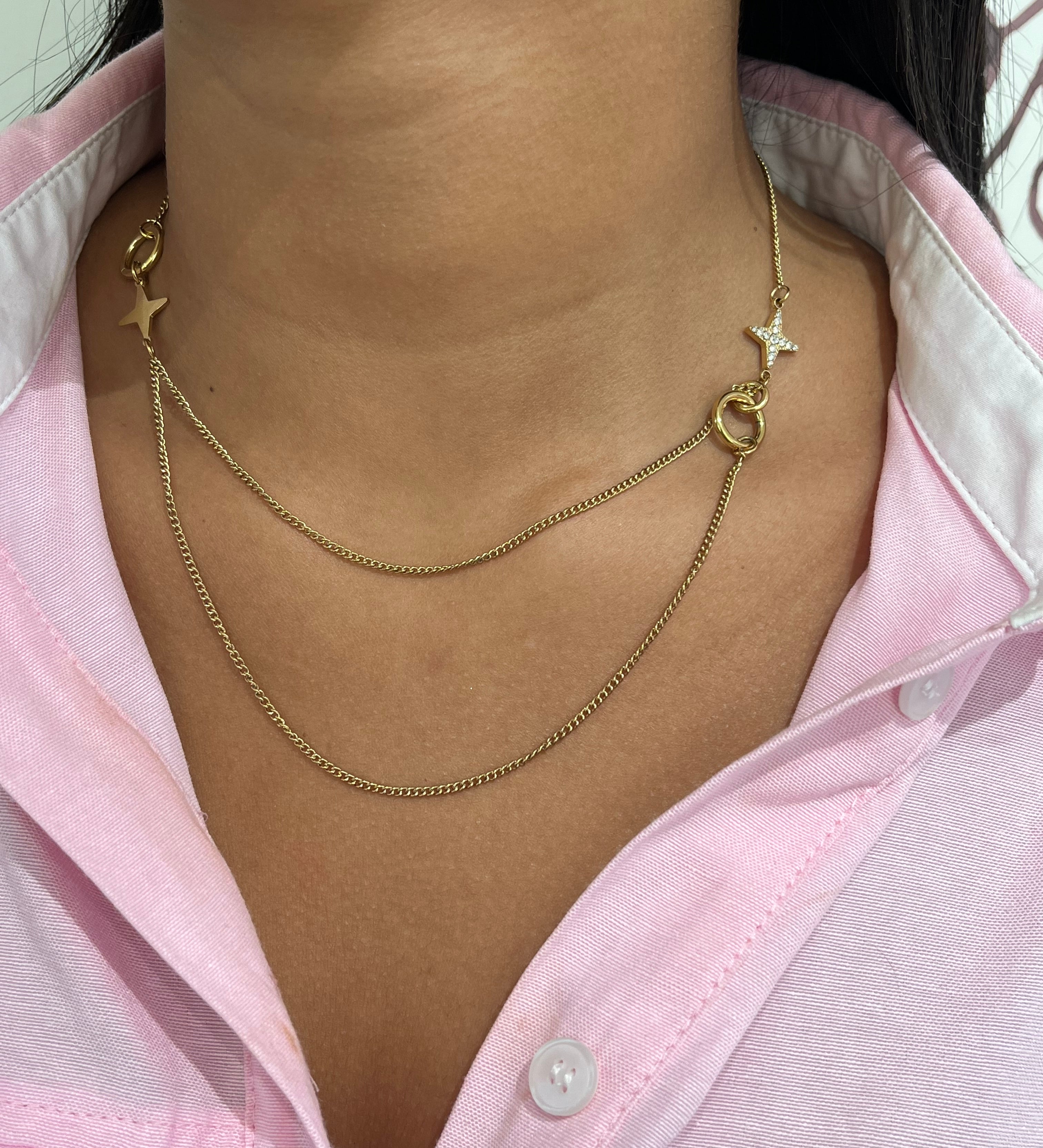 Gros plan sur le collier double rangs Stars Dream en acier inoxydable avec ses détails d'étoiles asymétriques sur le décolleté - Ordiajade