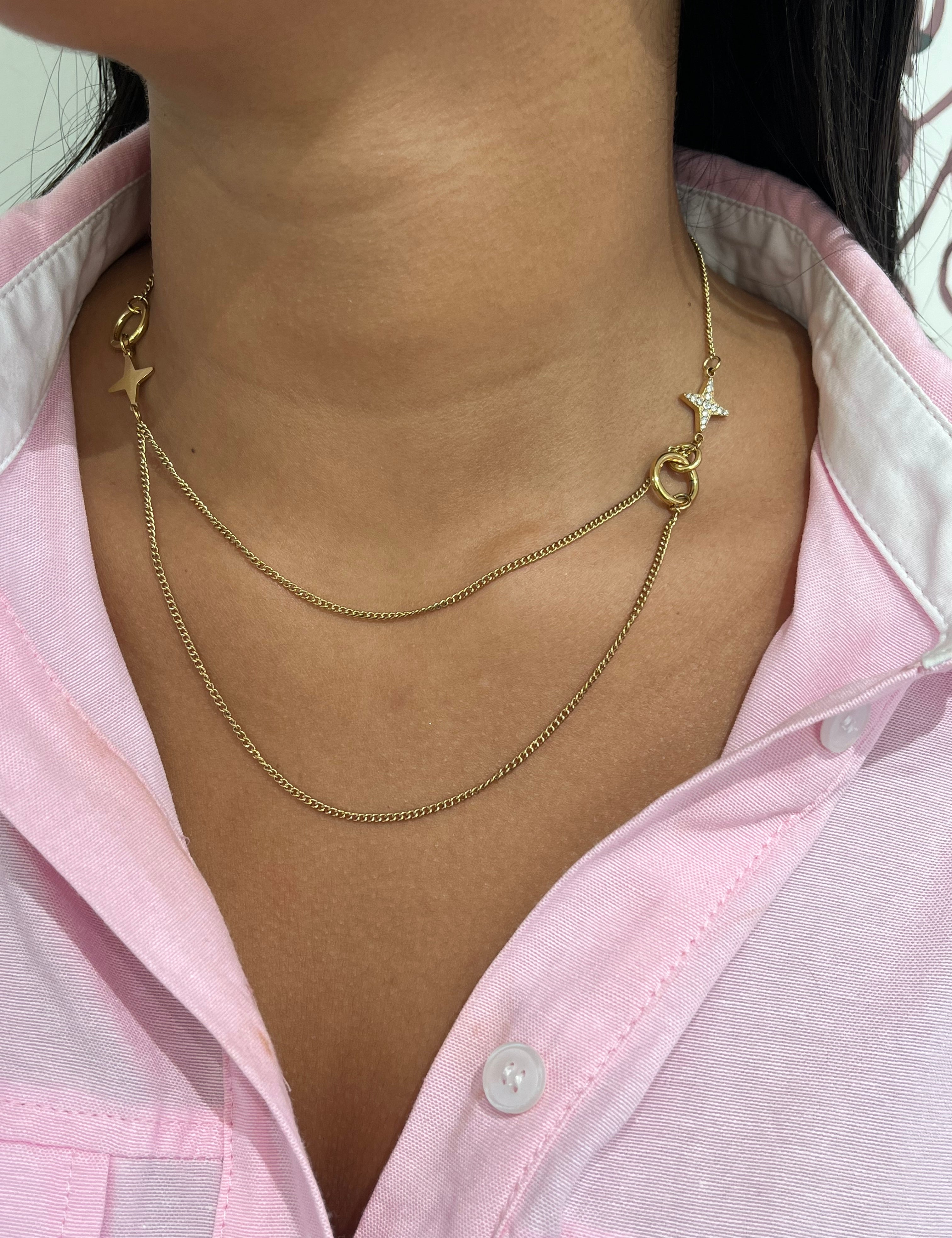 Gros plan sur le collier double rangs Stars Dream en acier inoxydable avec ses détails d'étoiles asymétriques sur le décolleté - Ordiajade