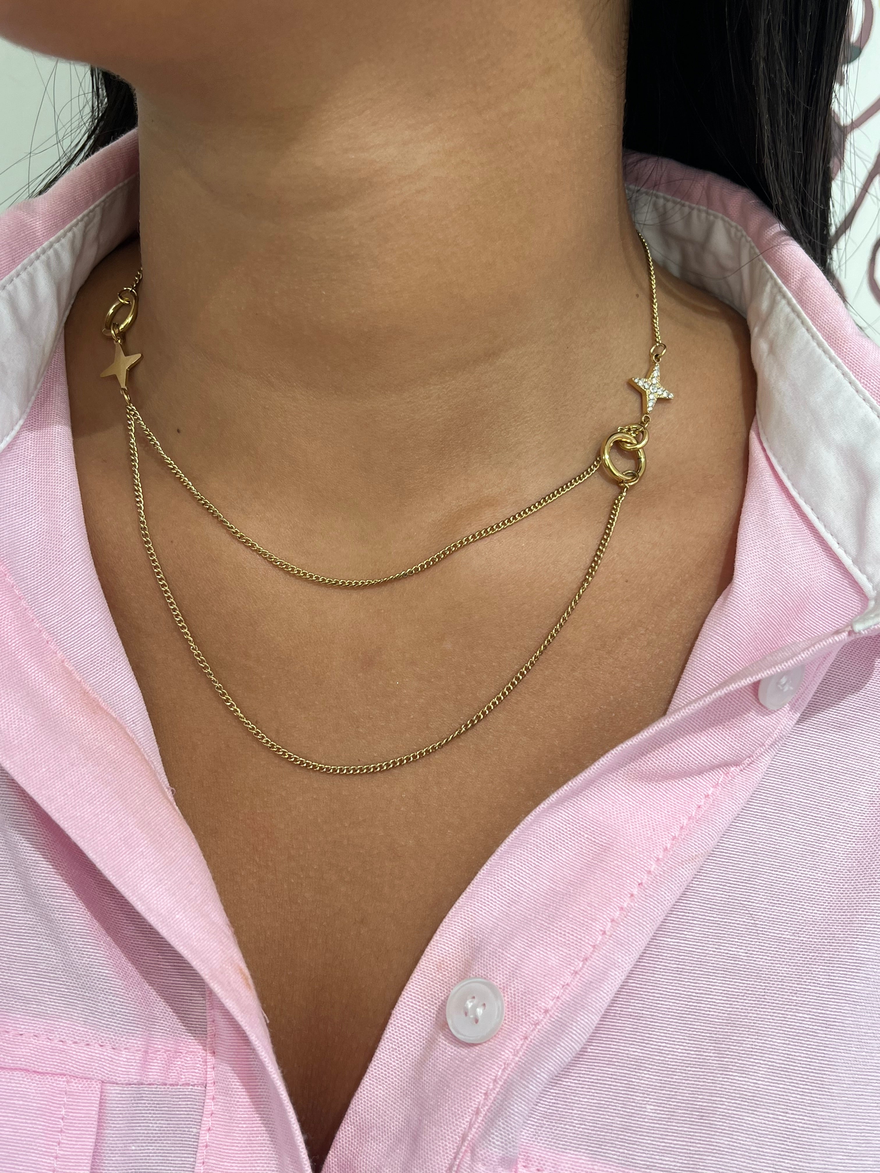 Gros plan sur le collier double rangs Stars Dream en acier inoxydable avec ses détails d'étoiles asymétriques sur le décolleté - Ordiajade