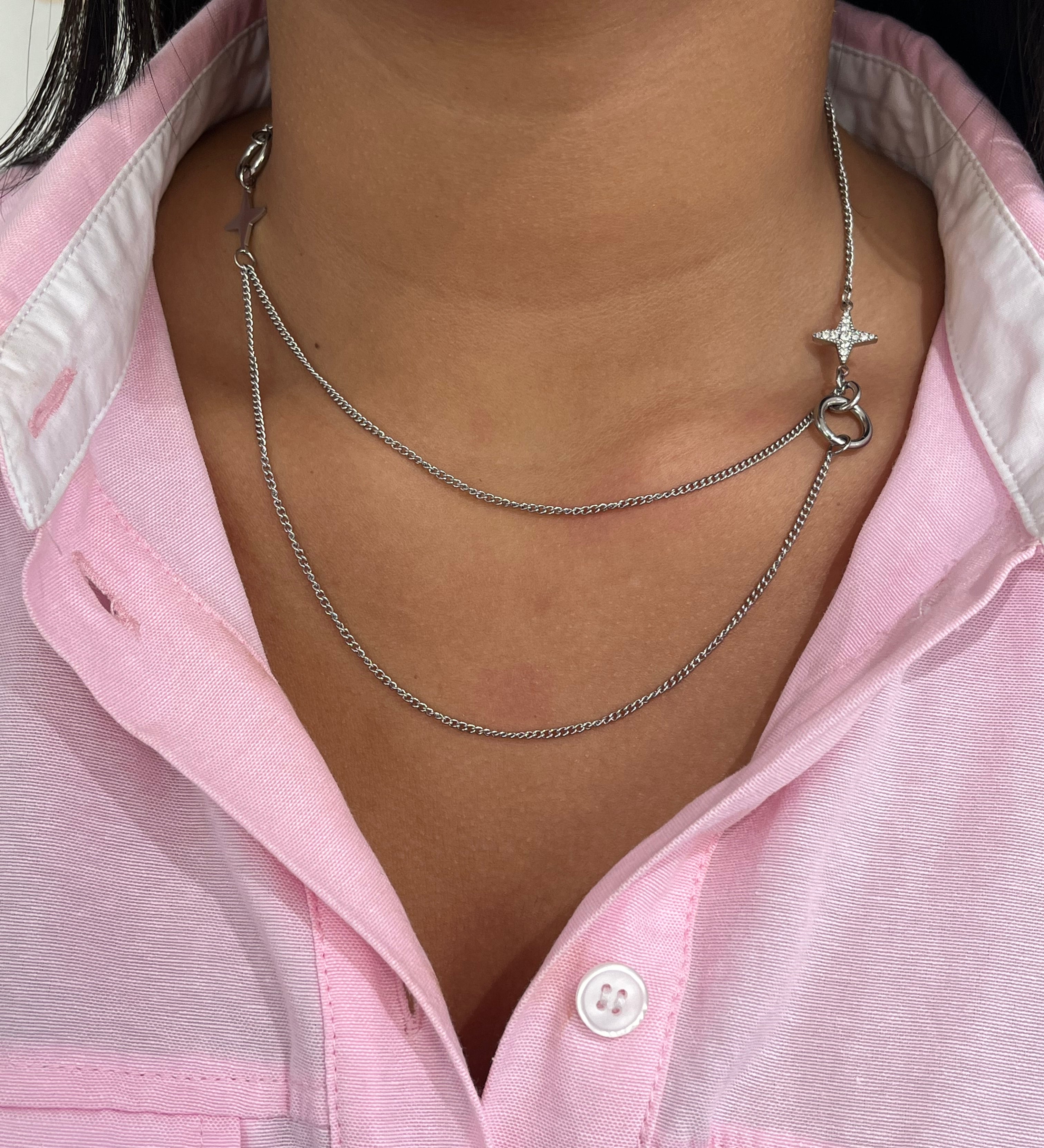 Gros plan sur le collier double rangs Stars Dream en acier inoxydable argenté avec ses détails d'étoiles asymétriques sur le décolleté - Ordiajade