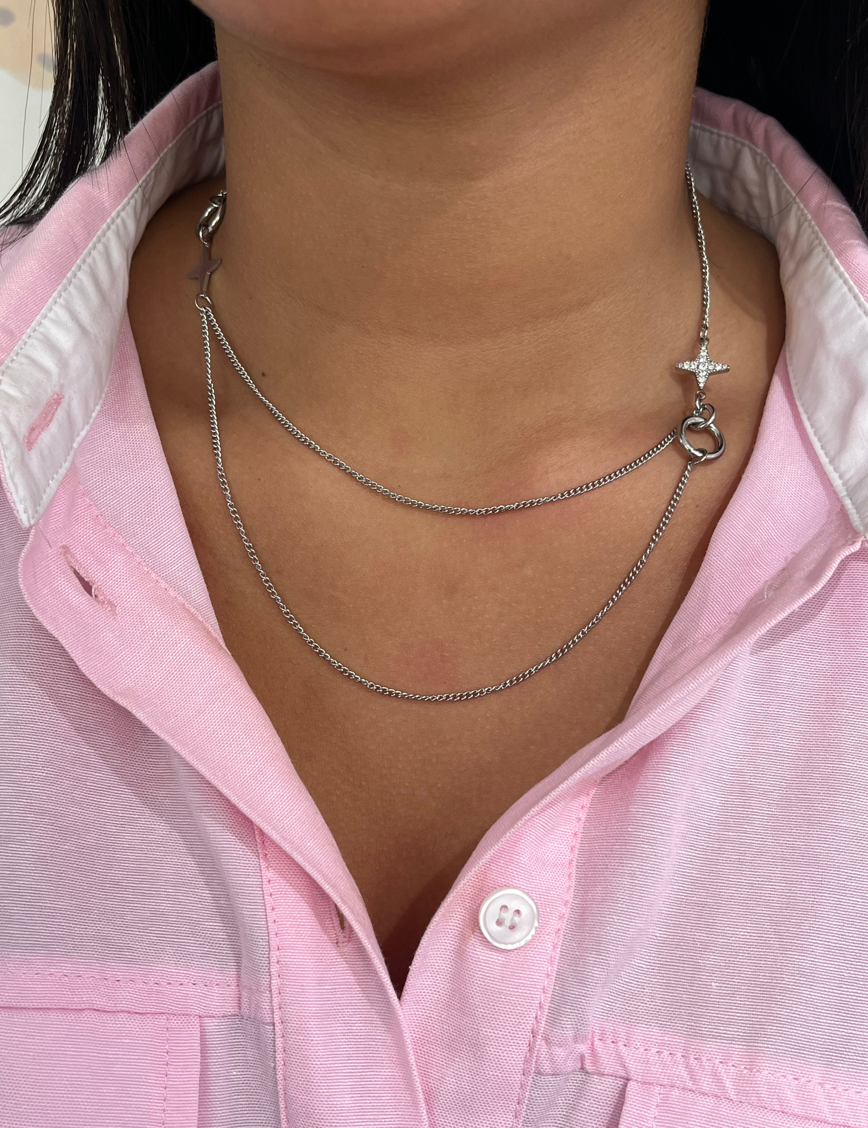 Gros plan sur le collier double rangs Stars Dream en acier inoxydable argenté avec ses détails d'étoiles asymétriques sur le décolleté - Ordiajade