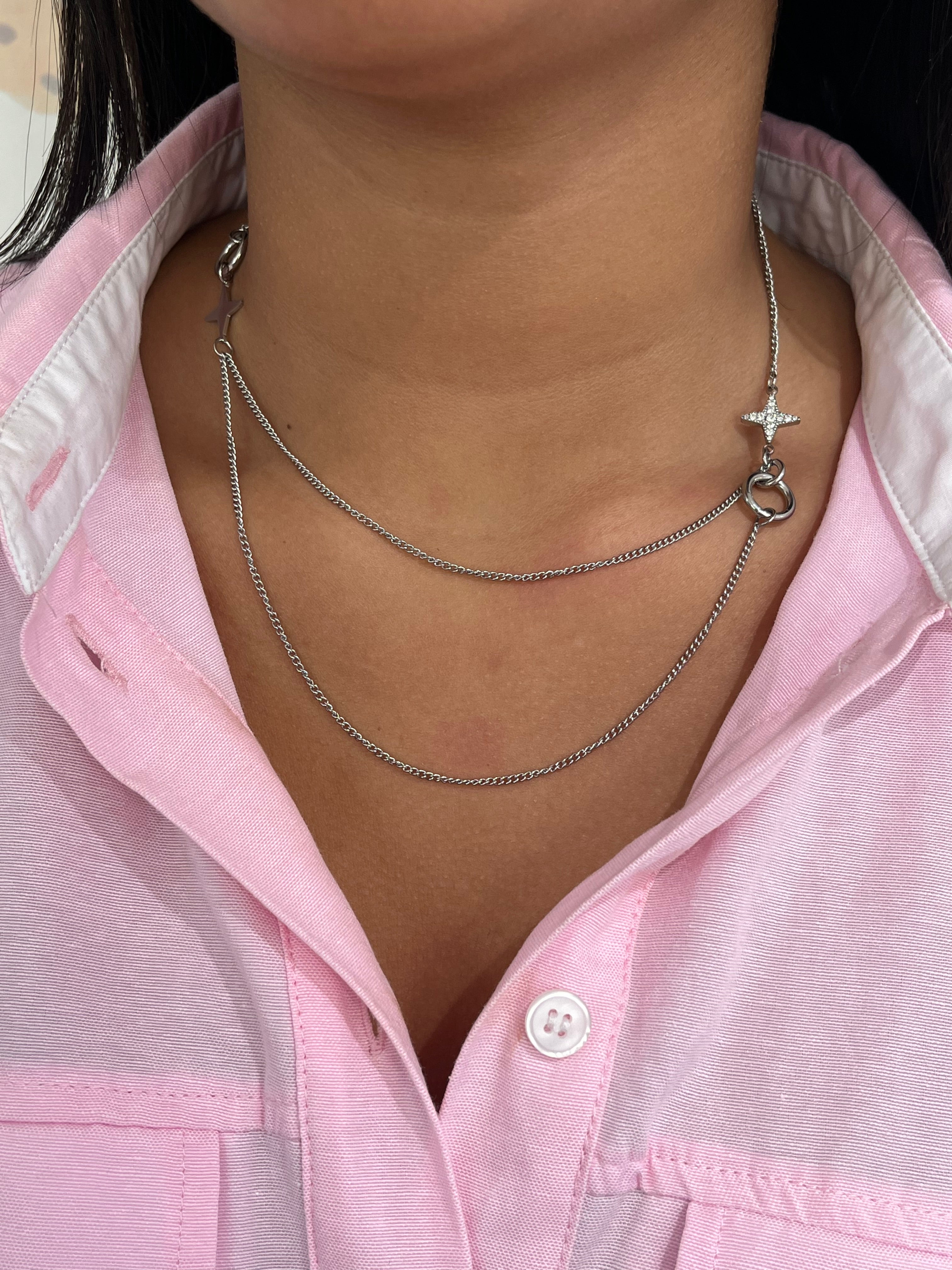 Gros plan sur le collier double rangs Stars Dream en acier inoxydable argenté avec ses détails d'étoiles asymétriques sur le décolleté - Ordiajade