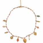 Collier fin doré Éléonore en acier inoxydable orné de petites perles colorées et de breloques suspendues posé à plat - Ordiajade