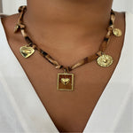 Collier statement léopard sur ruban marron avec médailles dorées et cœur sacré.