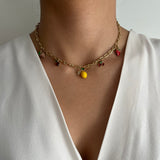 Collier Lima en acier inoxydable doré avec breloques fruits colorés porté au cou - Ordiajade