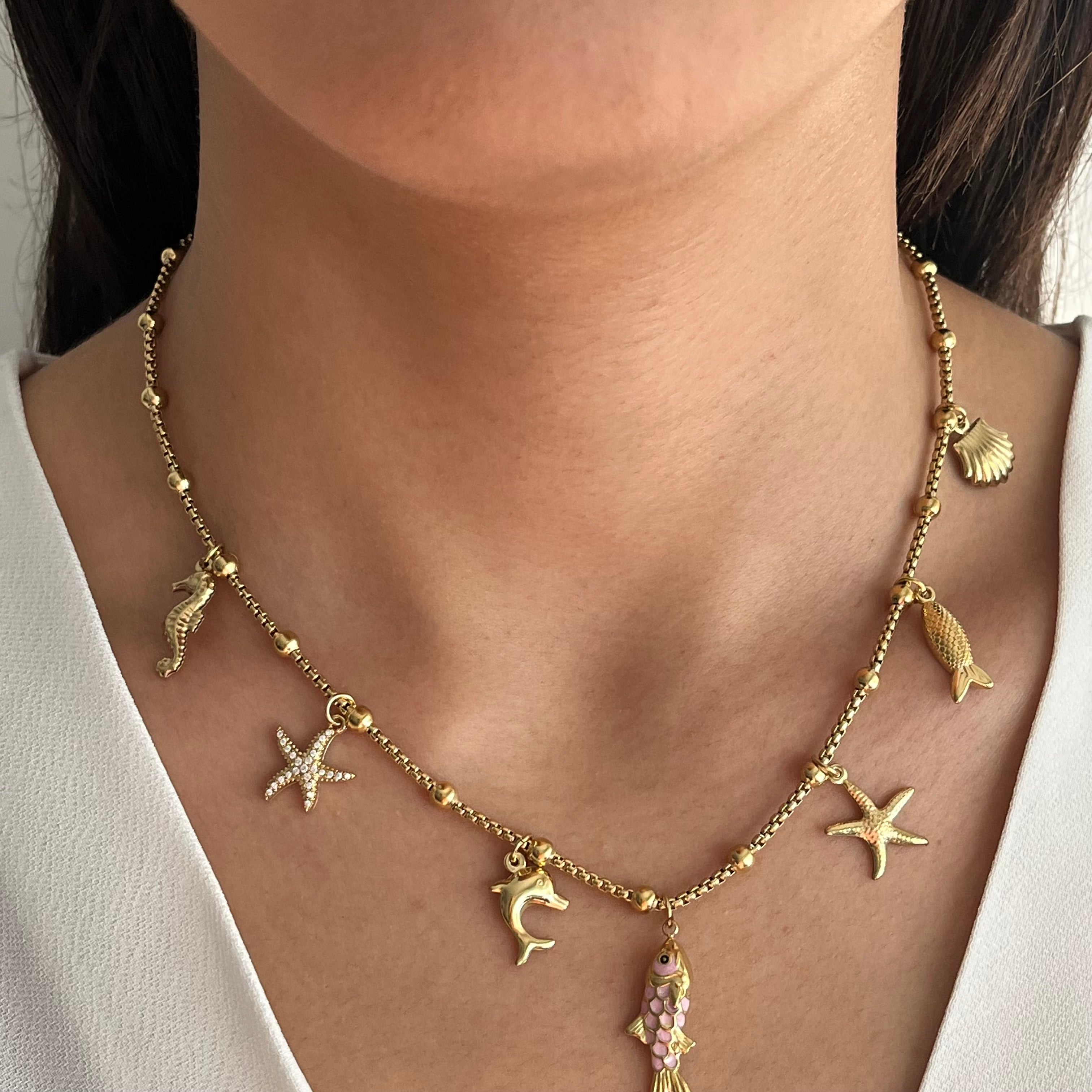Collier Maris en acier inoxydable doré avec pampilles marines dauphin et étoiles de mer porté au cou - Ordiajade
