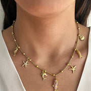 Collier Maris en acier inoxydable doré avec pampilles marines dauphin et étoiles de mer porté au cou - Ordiajade
