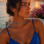 Collier Nacri Blue lumineux porté au cou avec une tenue bleue au coucher du soleil Ordiajade