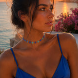 Collier Nacri Blue lumineux porté au cou avec une tenue bleue au coucher du soleil Ordiajade