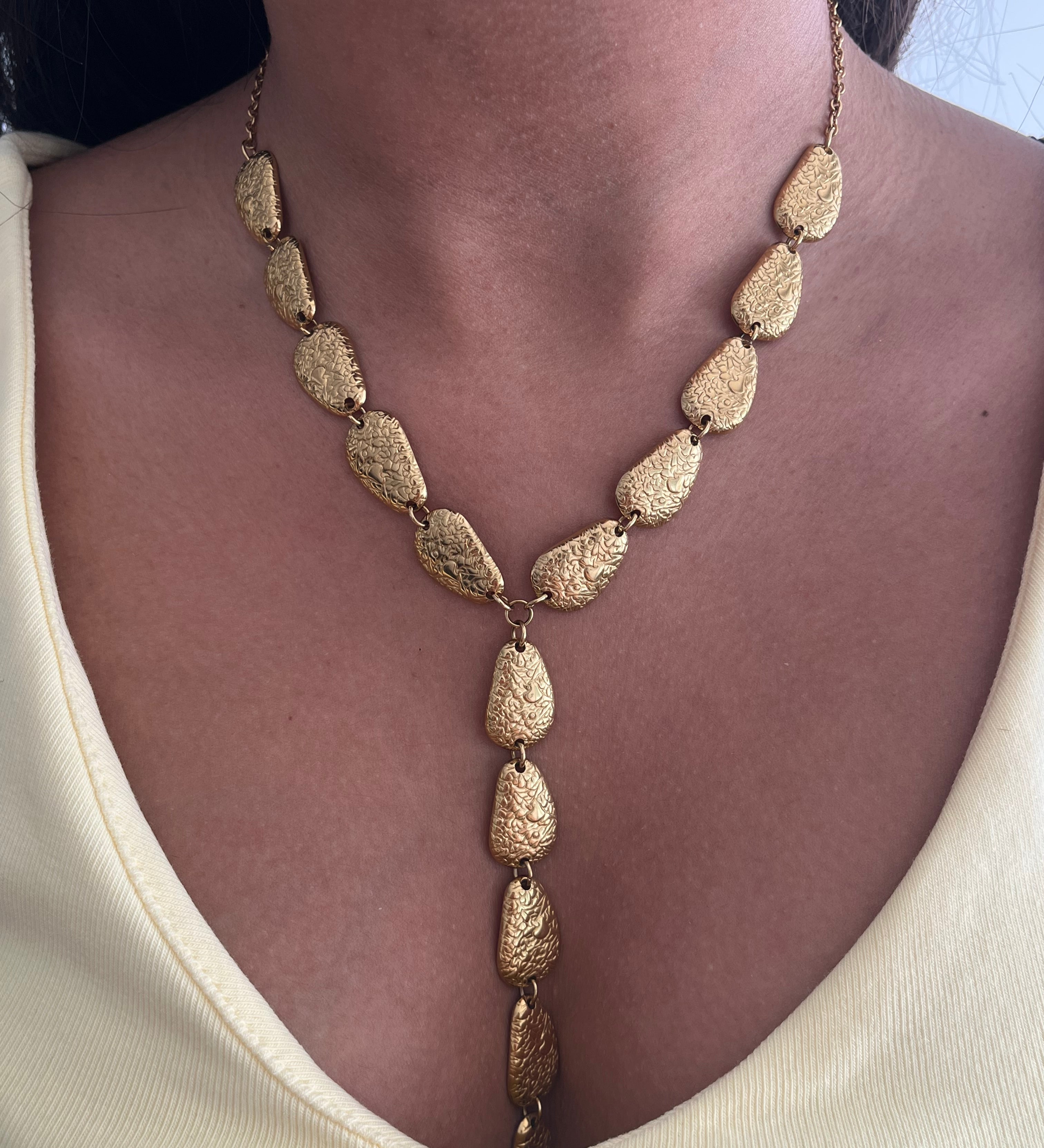 Collier plongeant en Y Nea en acier inoxydable doré avec maillons ovales graphiques porté au cou - Ordiajade