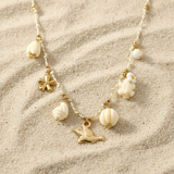 Collier doré oiseau et tortue en acier inoxydable sur fond sable - Ordiajade