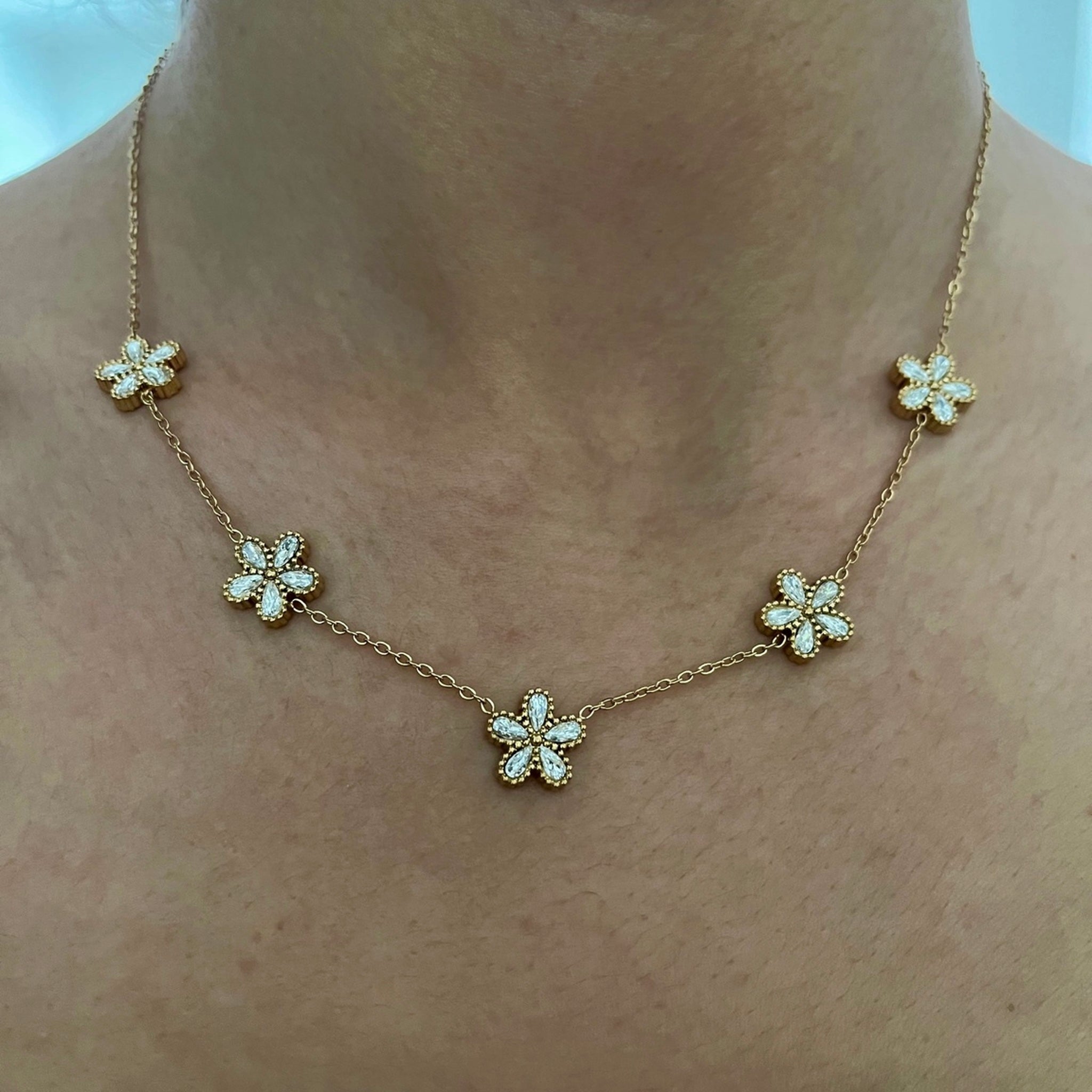 Collier Ora doré en acier inoxydable avec petites fleurs strassées porté au cou - Ordiajade