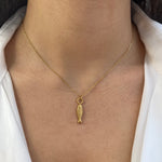 Collier doré à pendentif poisson stylisé en acier inoxydable porté au cou - Ordiajade
