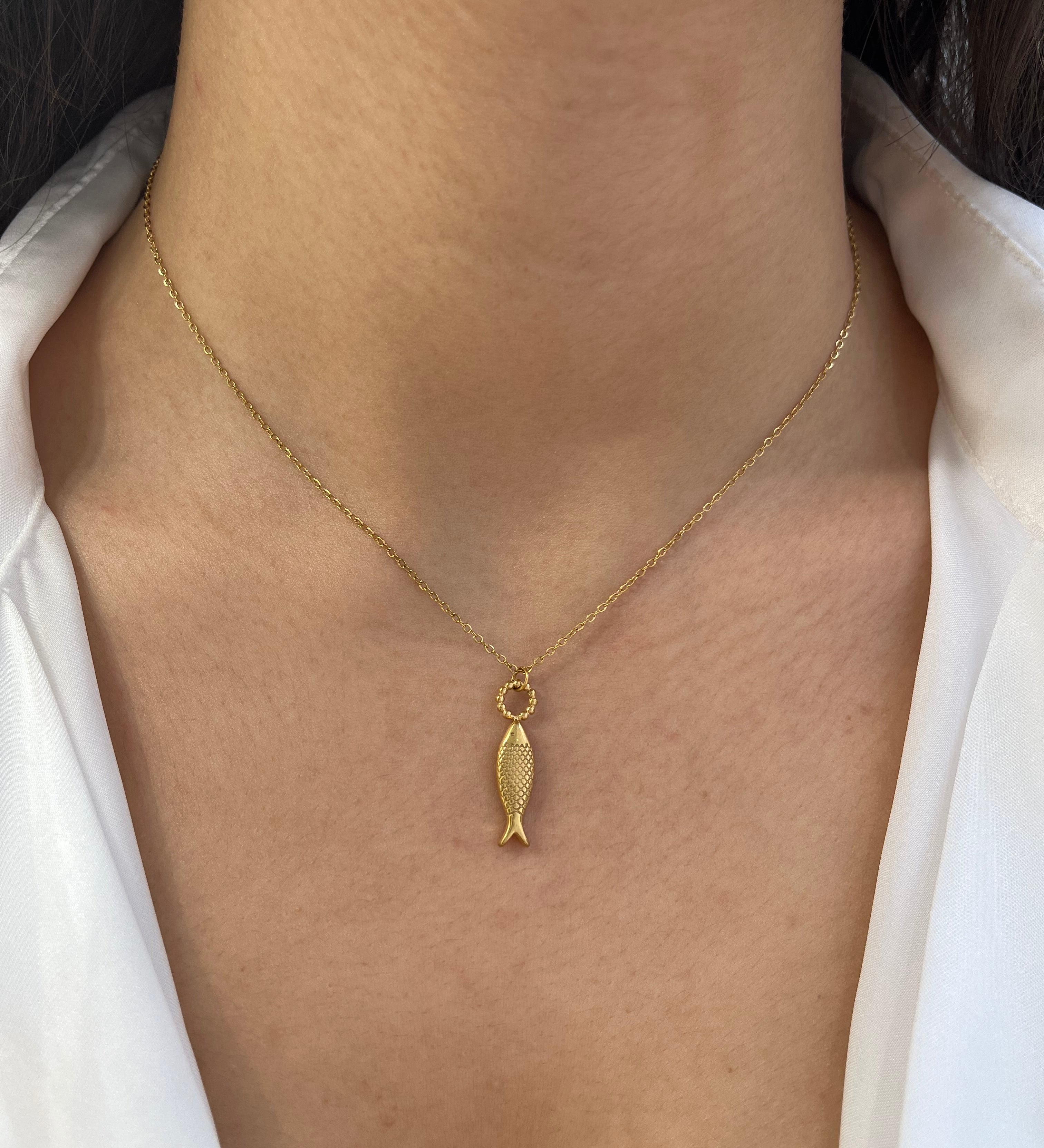Collier doré à pendentif poisson stylisé en acier inoxydable porté au cou - Ordiajade