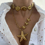 Collier Sora doré superposé avec d'autres bijoux motifs marins - Ordiajade
