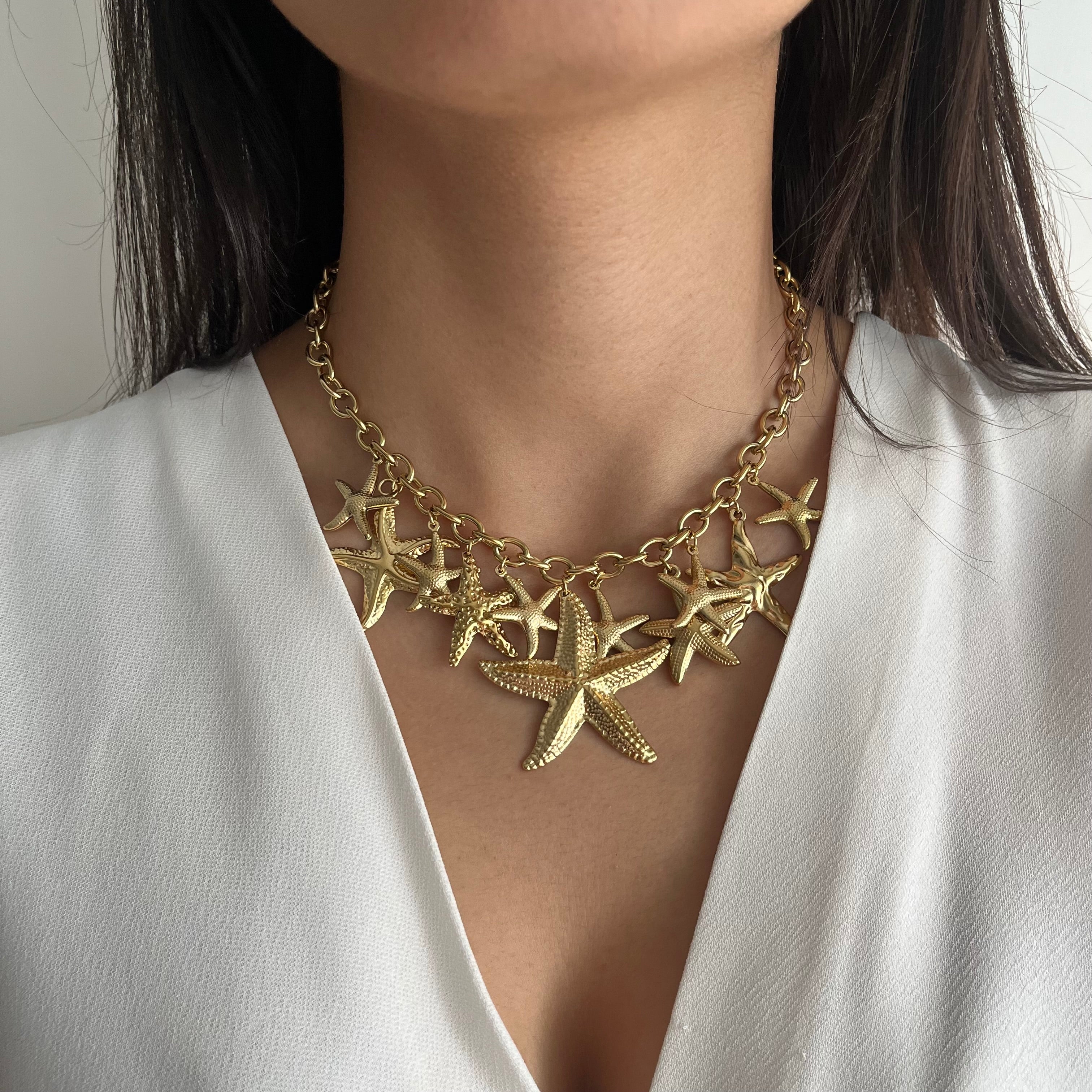Collier Yuna en acier inoxydable doré à cascade d'étoiles de mer porté sur le décolleté - Ordiajade