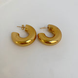 Paire de boucles d'oreilles créoles sculpturales Chéri dorées sur fond blanc - Ordiajade