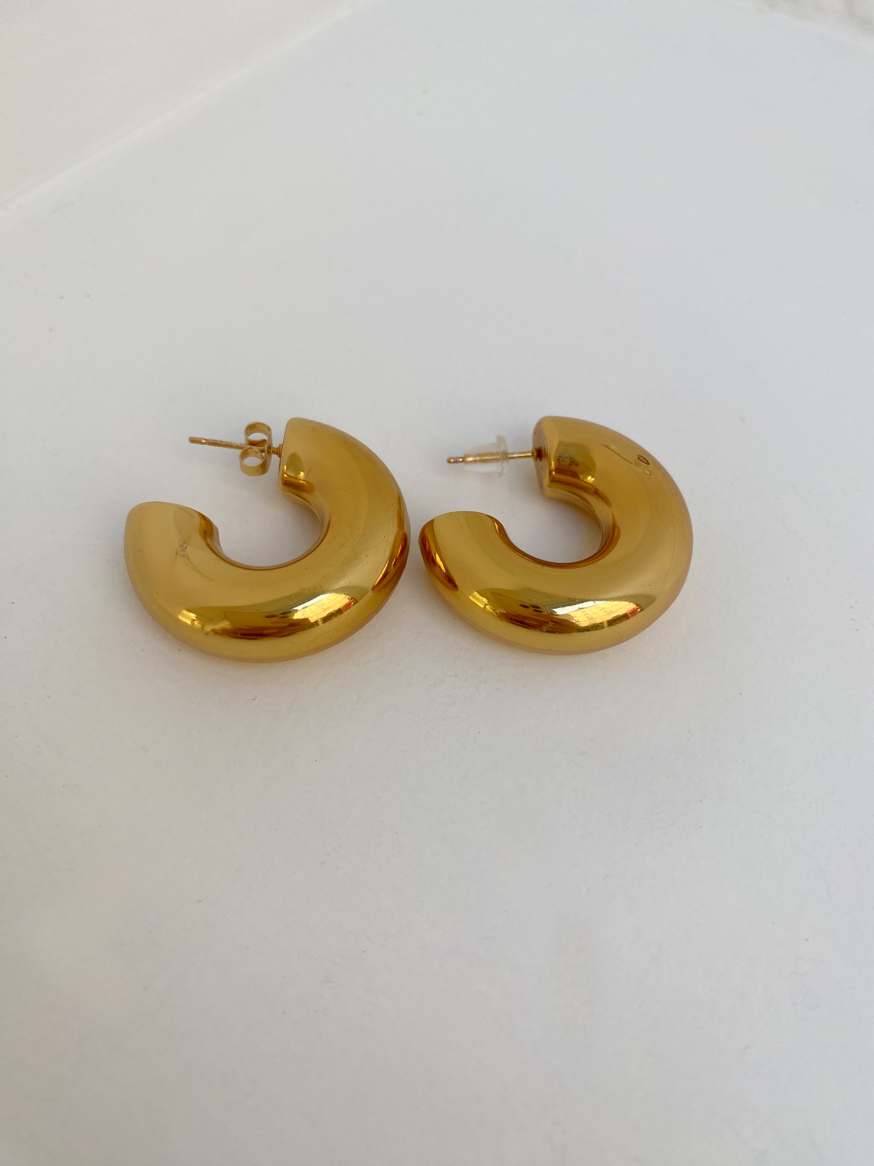 Paire de boucles d'oreilles créoles sculpturales Chéri dorées sur fond blanc - Ordiajade