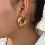 Gros plan des boucles d'oreilles créoles larges et bombées Chéri portées au lobe - Ordiajade