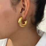 Gros plan des boucles d'oreilles créoles larges et bombées Chéri portées au lobe - Ordiajade