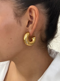 Gros plan des boucles d'oreilles créoles larges et bombées Chéri portées au lobe - Ordiajade
