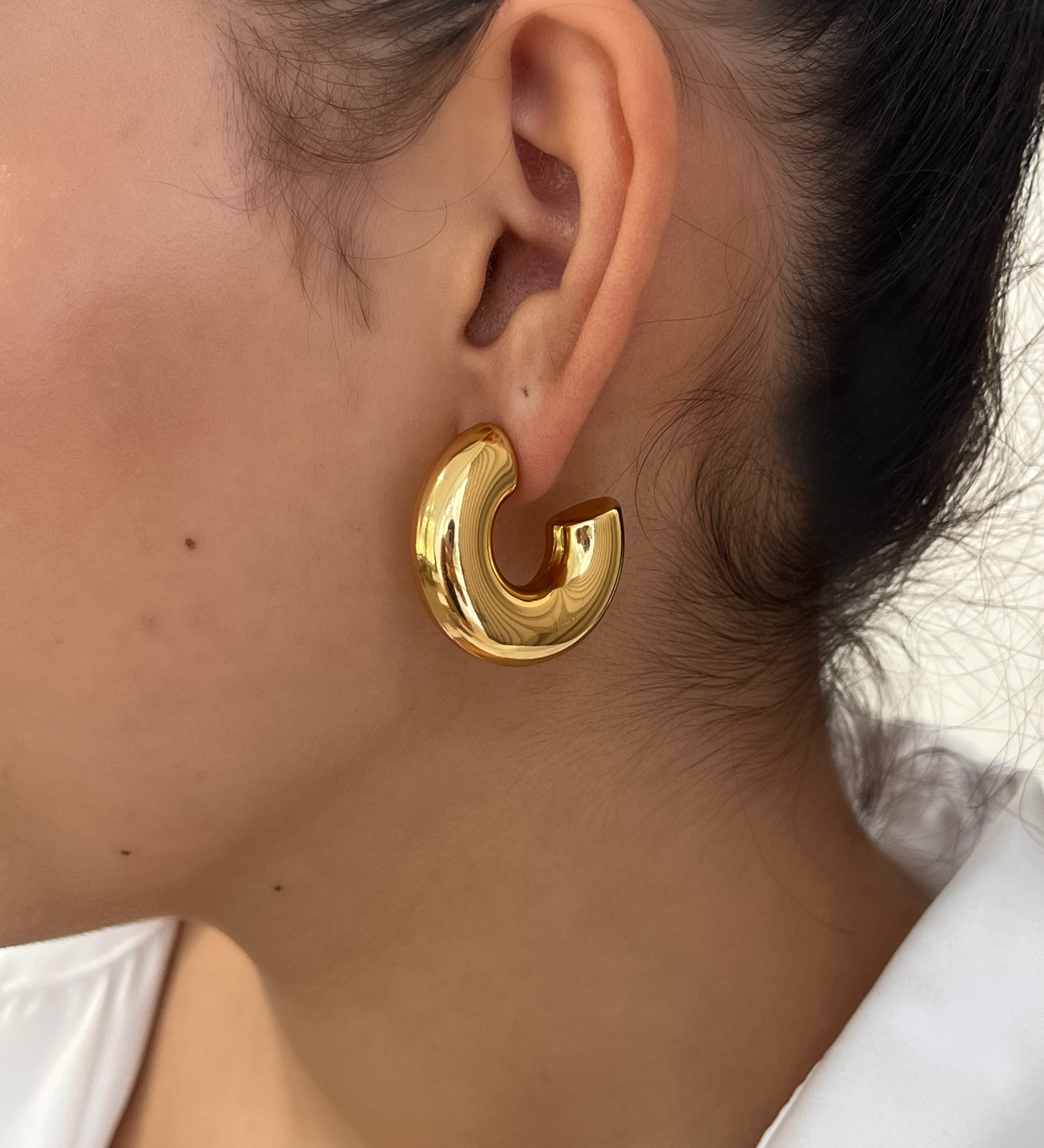 Gros plan des boucles d'oreilles créoles larges et bombées Chéri portées au lobe - Ordiajade