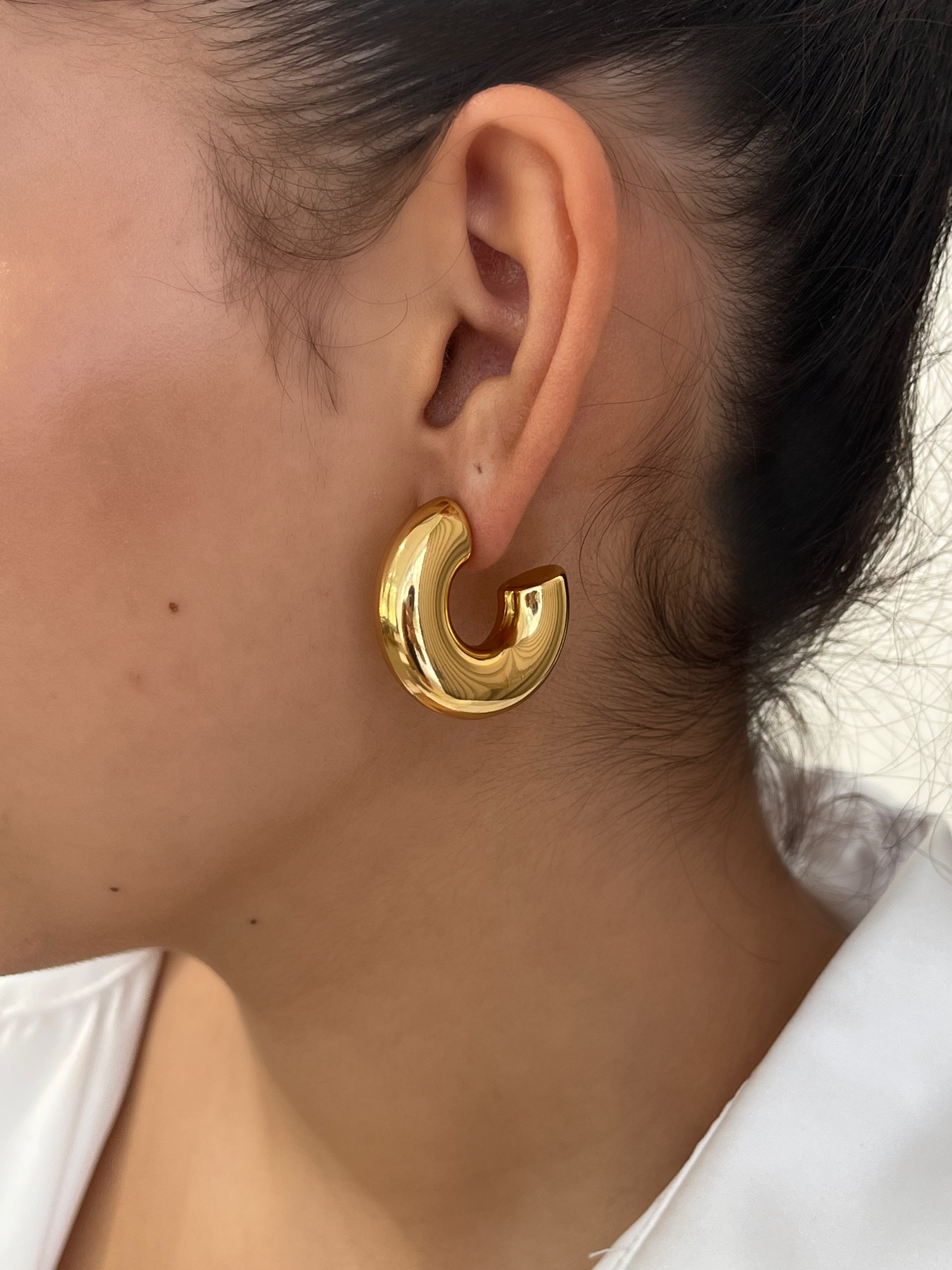 Gros plan des boucles d'oreilles créoles larges et bombées Chéri portées au lobe - Ordiajade