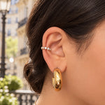 Ear cuff Triomphe doré à strass en acier inoxydable porté à l'oreille dans une rue parisienne - Ordiajade