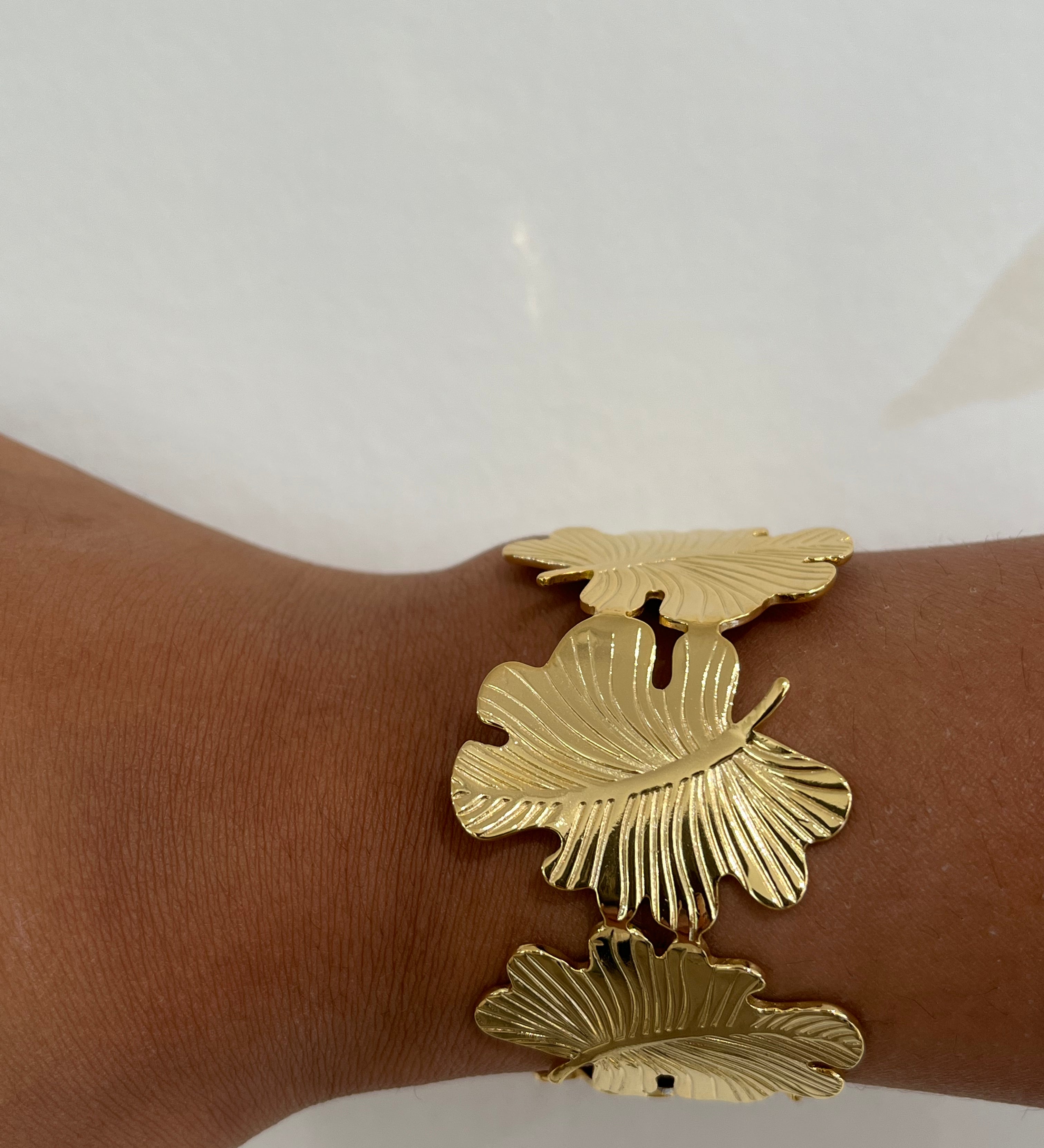 Bracelet jonc Gaara en acier inoxydable doré à motif feuilles porté au poignet - Ordiajade