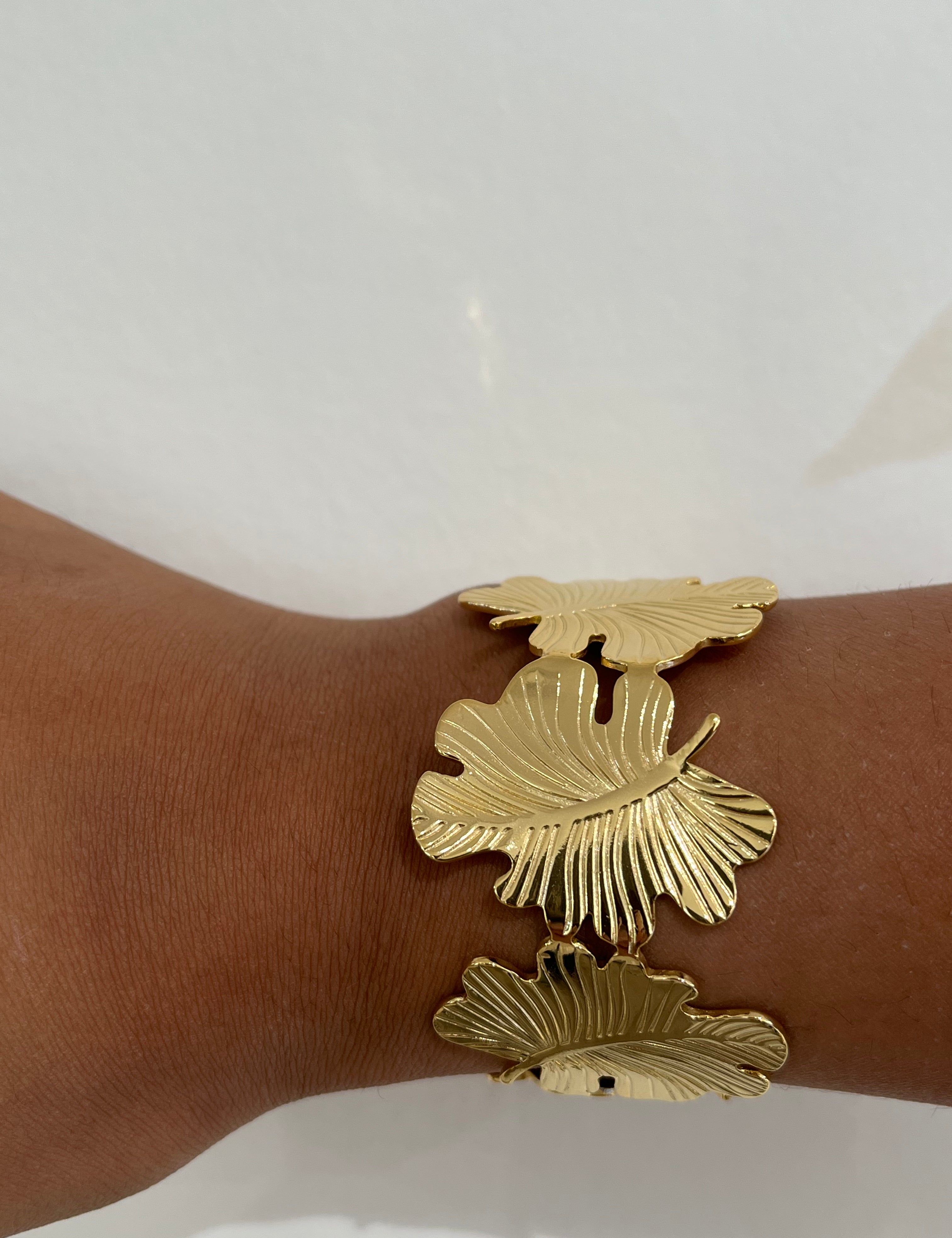 Bracelet jonc Gaara en acier inoxydable doré à motif feuilles porté au poignet - Ordiajade