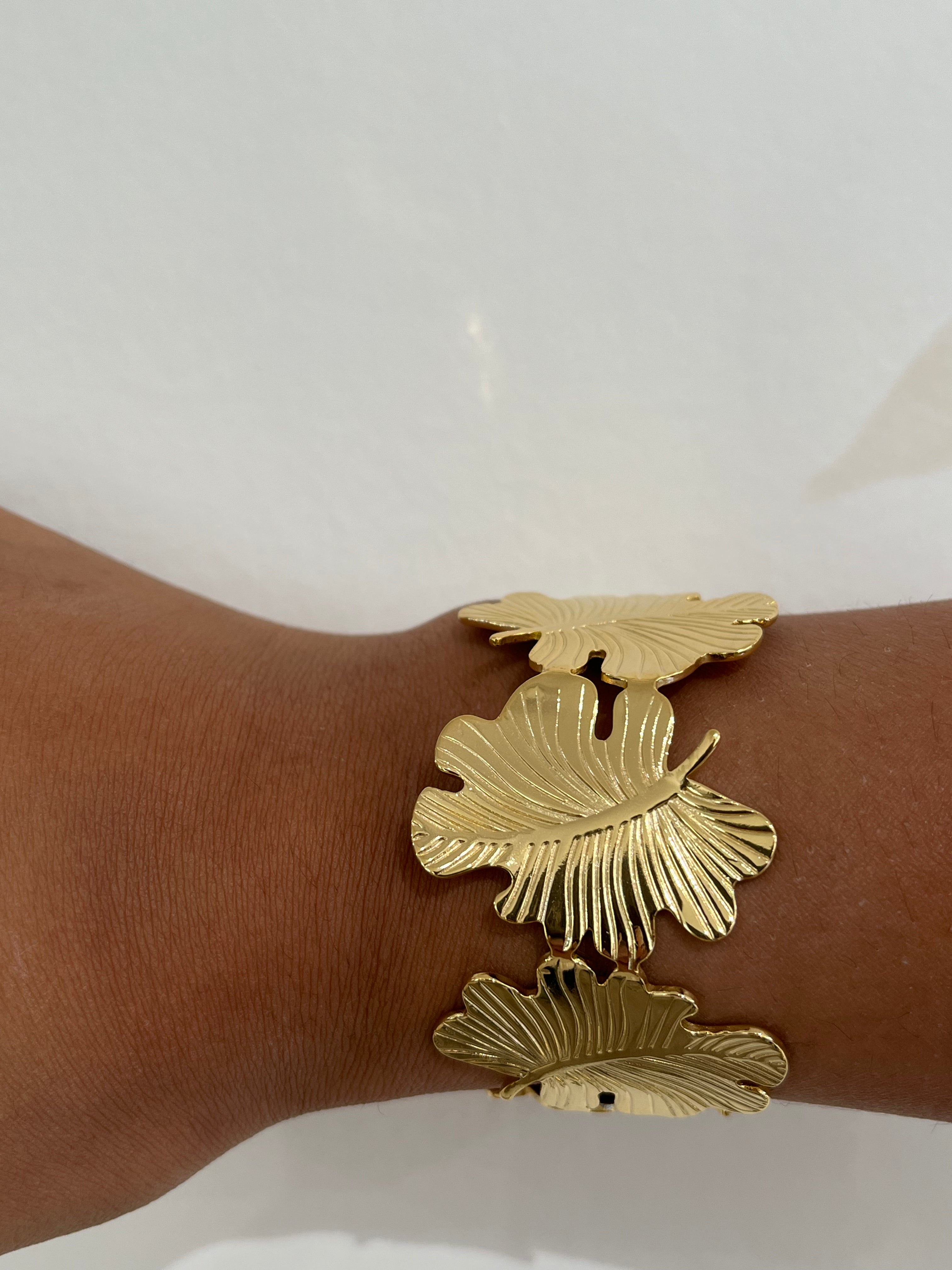 Bracelet jonc Gaara en acier inoxydable doré à motif feuilles porté au poignet - Ordiajade