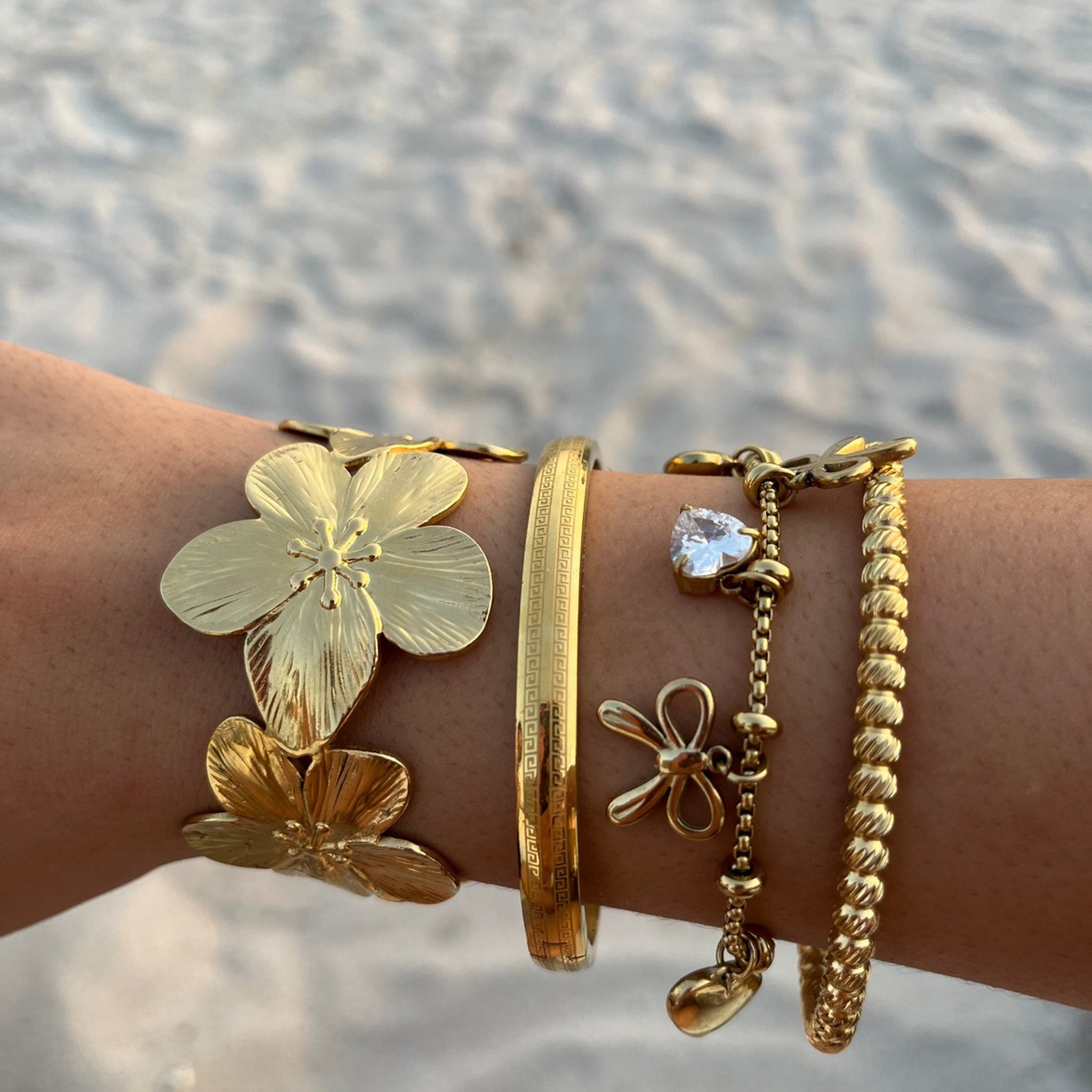 Jonc June doré porté en accumulation avec d'autres bracelets au poignet - Ordiajade