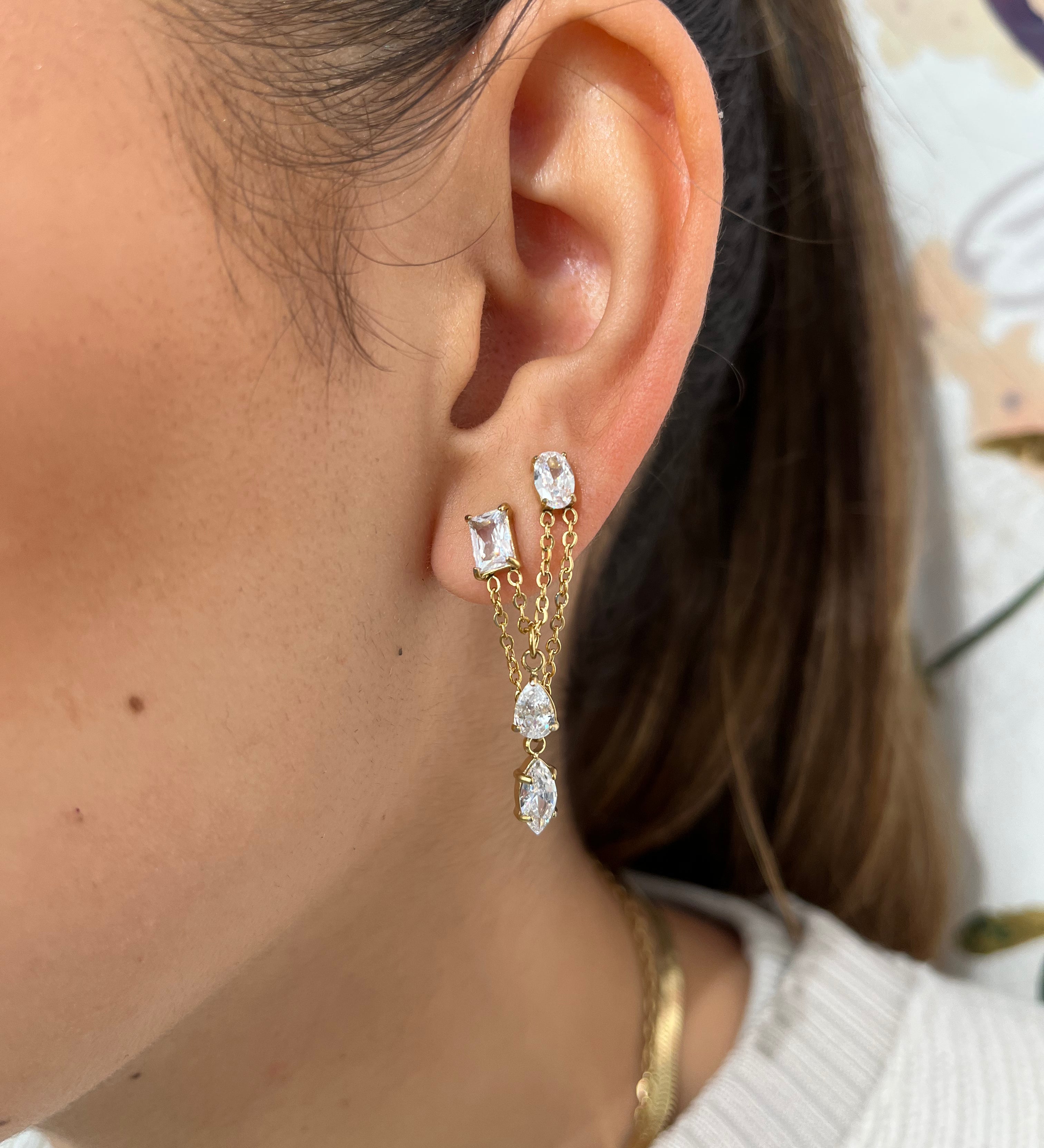 Mono-boucle Stella avec chaînes pendantes et pierres scintillantes portée à l'oreille.