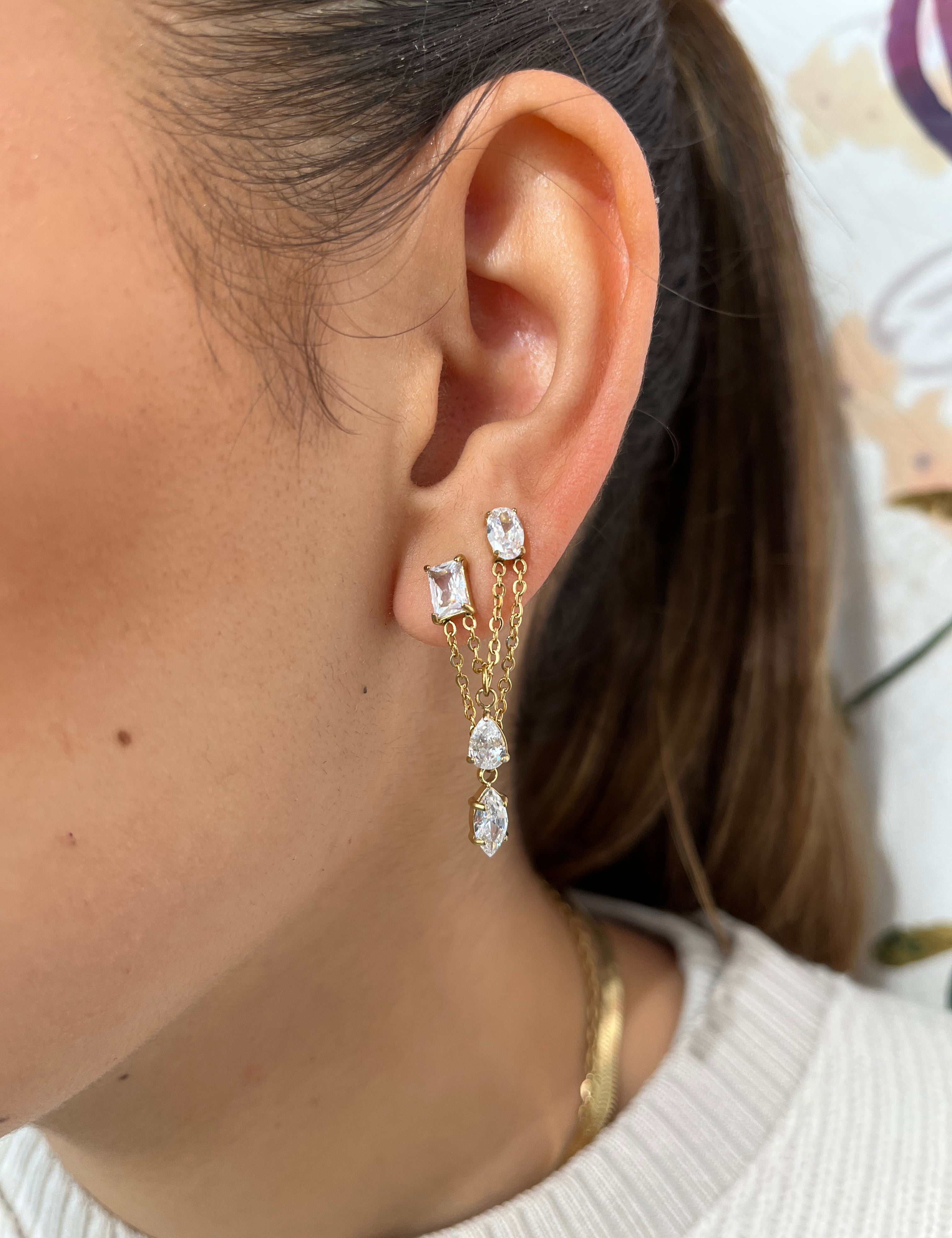 Mono-boucle Stella avec chaînes pendantes et pierres scintillantes portée à l'oreille.