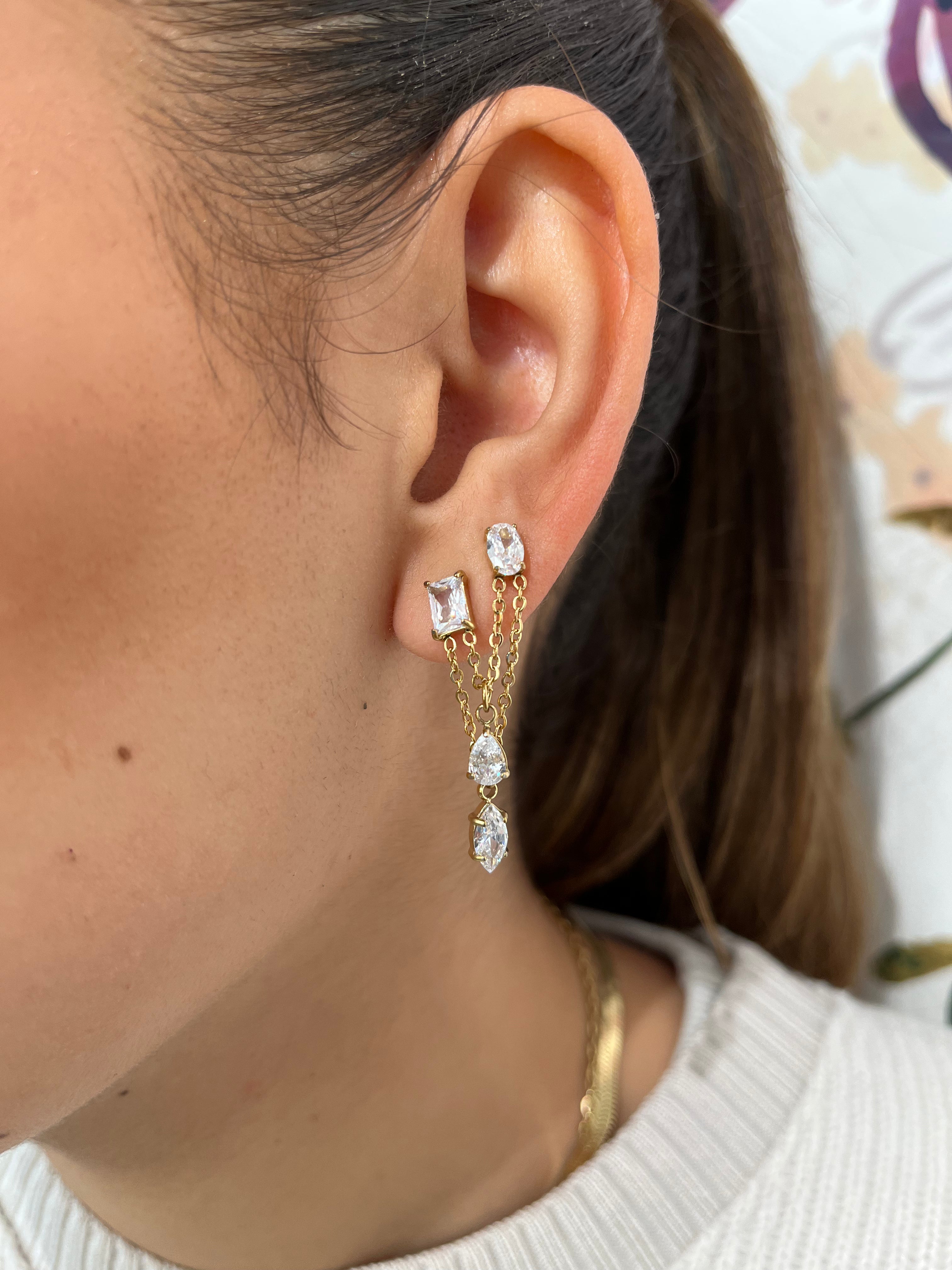 Mono-boucle Stella avec chaînes pendantes et pierres scintillantes portée à l'oreille.