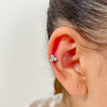 Piercing How en acier inoxydable avec trois petits cristaux, porté au cartilage de l'oreille.
