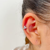 Piercing How en acier inoxydable avec trois petits cristaux, porté au cartilage de l'oreille.