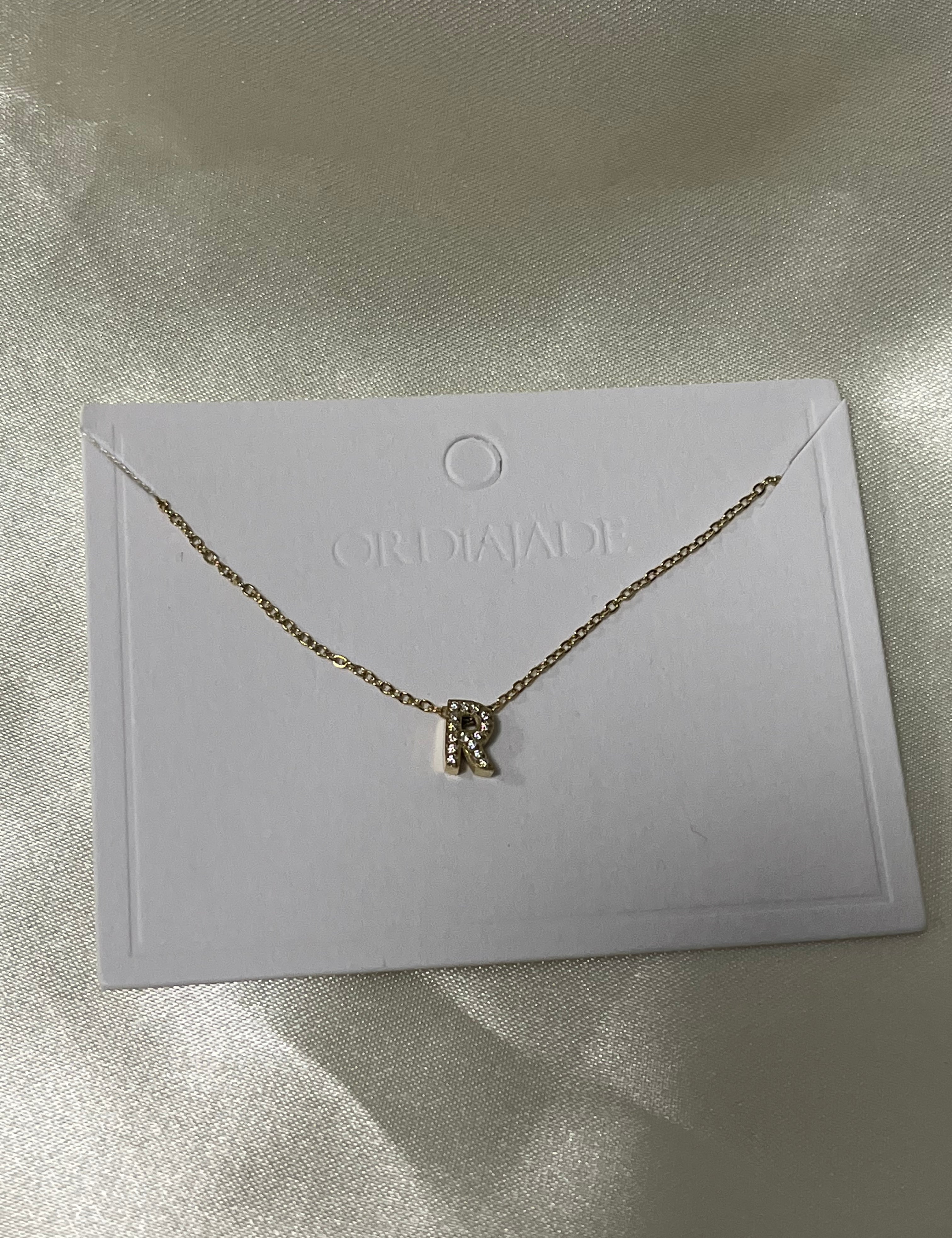 Collier Cuty doré à initiale R sertie de strass, sur sa carte de présentation - Ordiajade