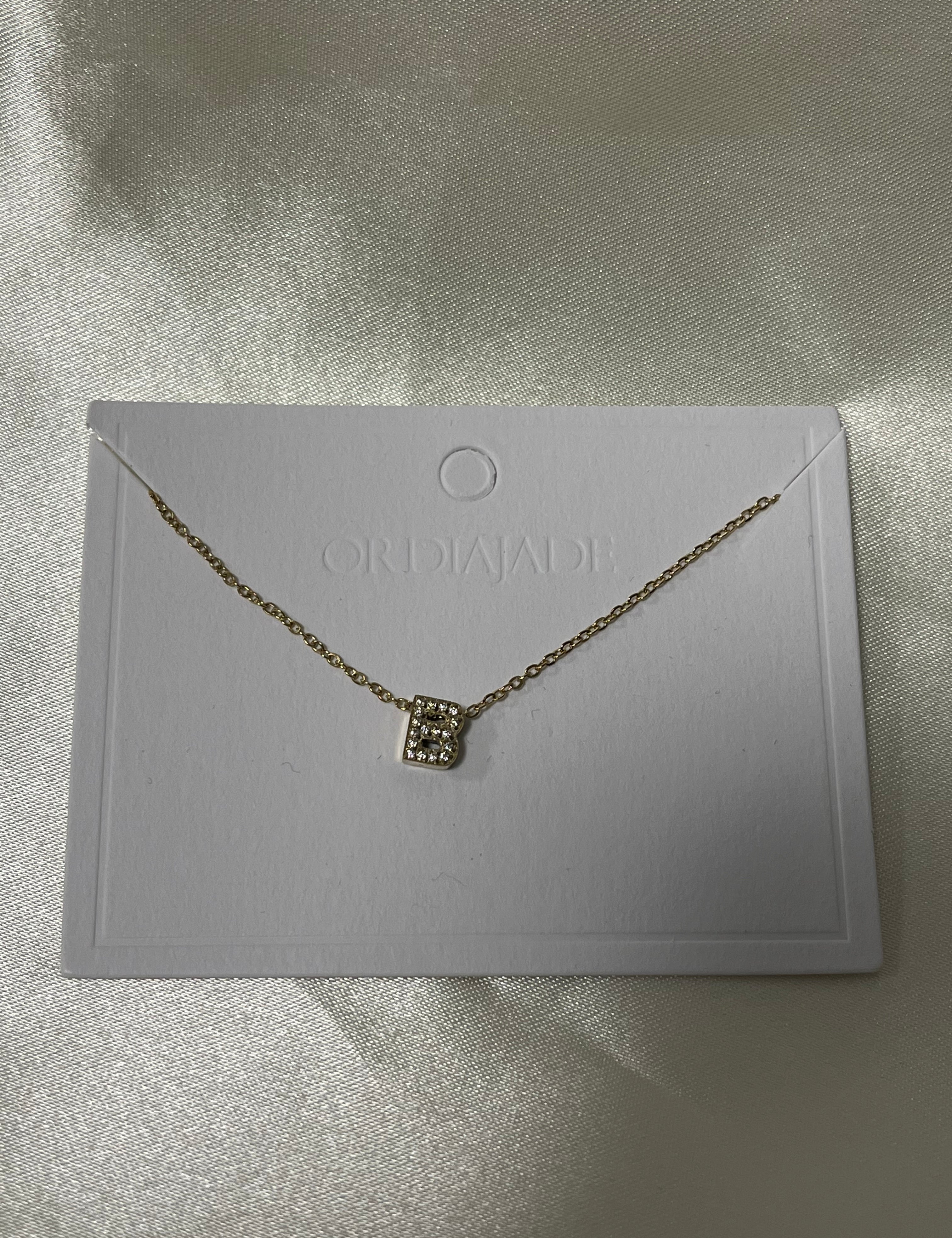 Collier Cuty doré à initiale B sertie de strass, sur sa carte de présentation - Ordiajade