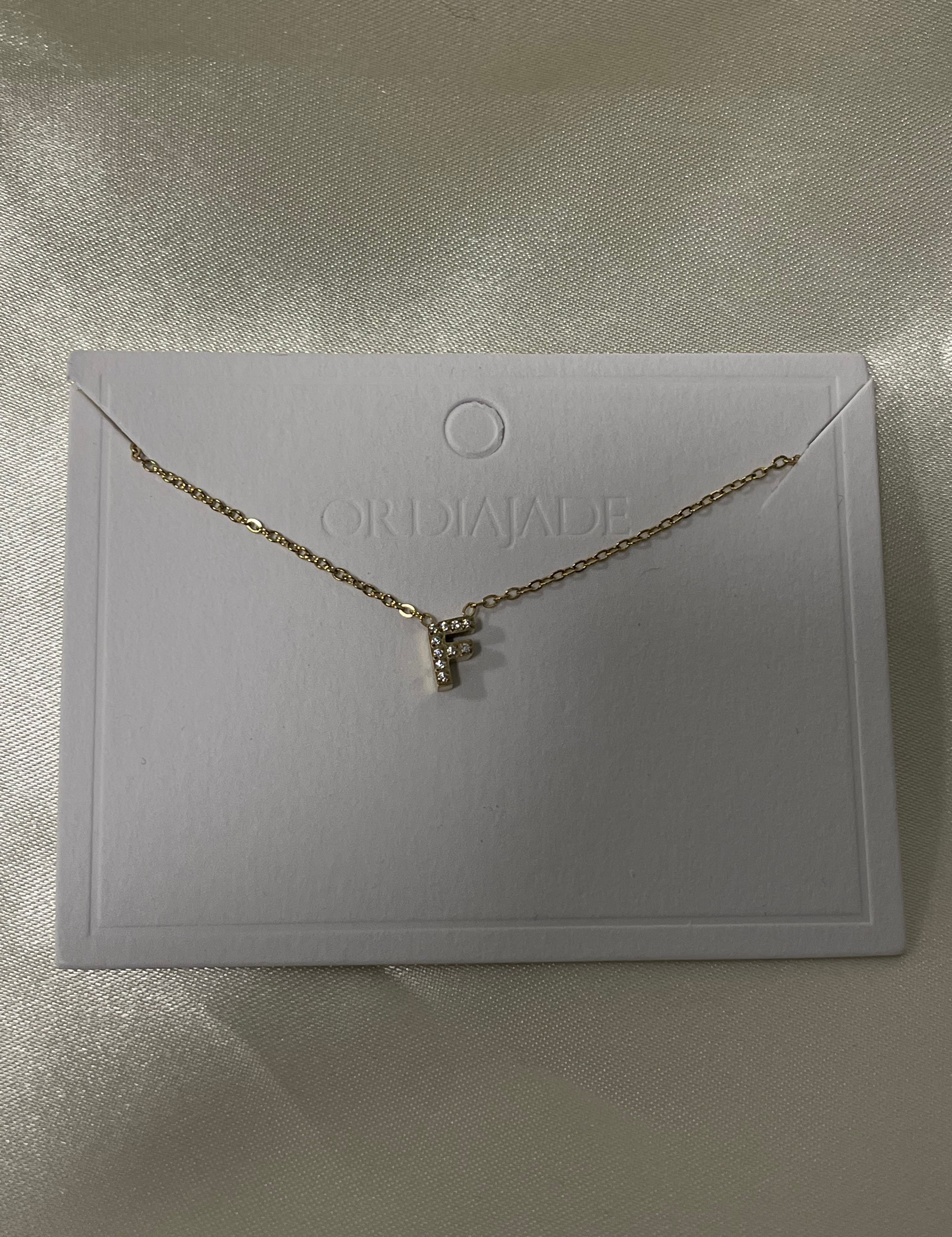 Collier Cuty doré à initiale F sertie de strass, sur sa carte de présentation - Ordiajade