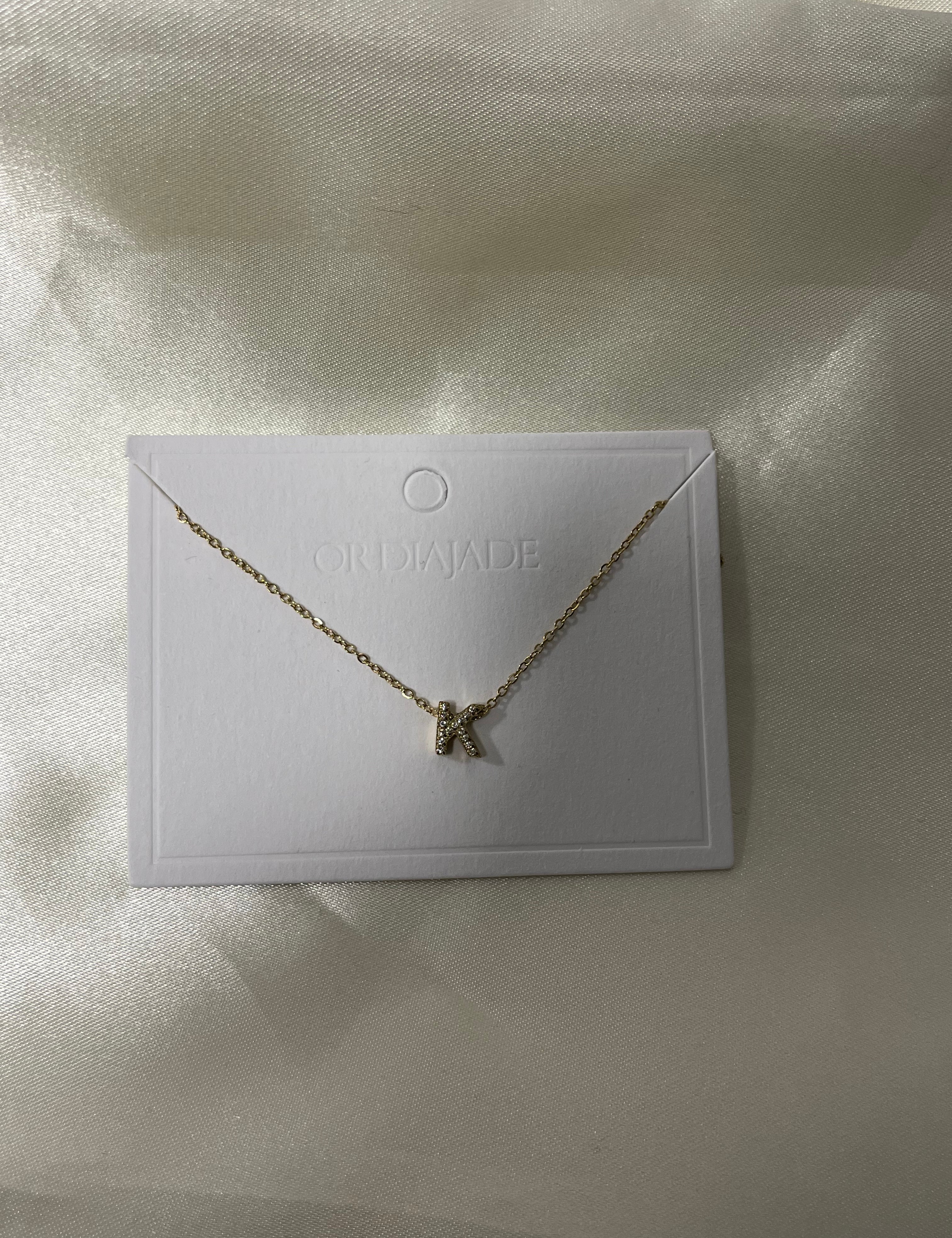 Collier Cuty doré à initiale K sertie de strass, sur sa carte de présentation - Ordiajade