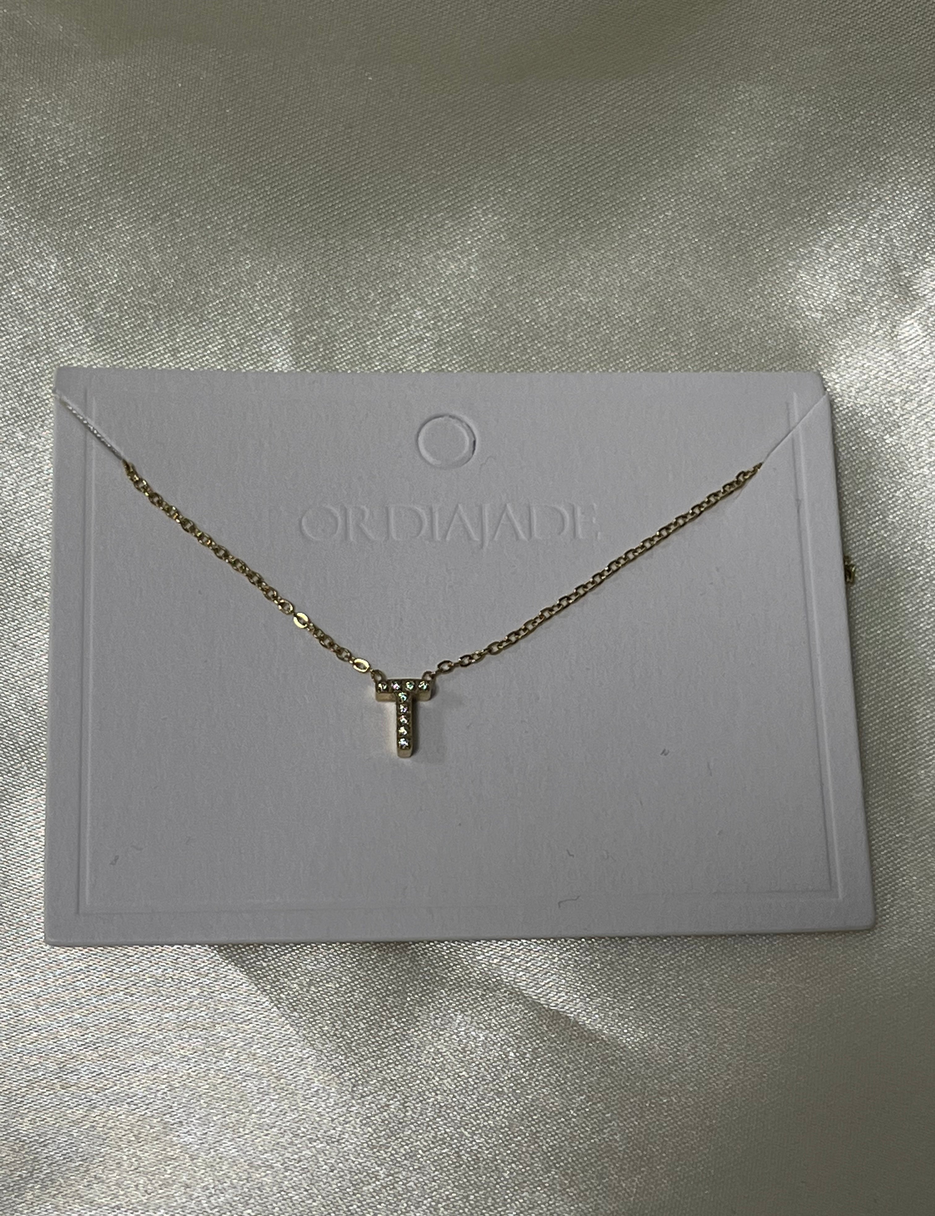 Collier Cuty doré à initiale T sertie de strass, sur sa carte de présentation - Ordiajade