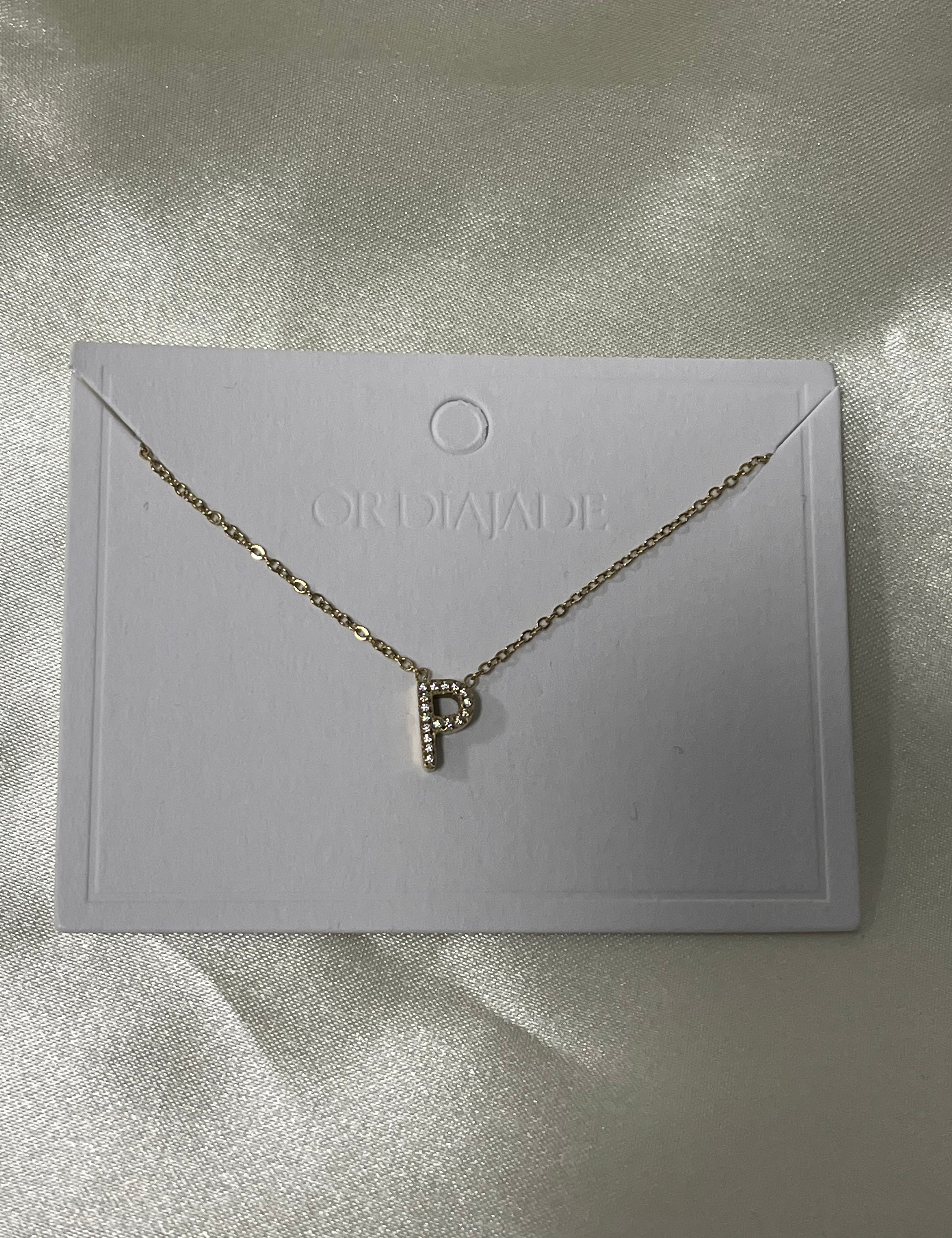 Collier Cuty doré à initiale P sertie de strass, sur sa carte de présentation - Ordiajade