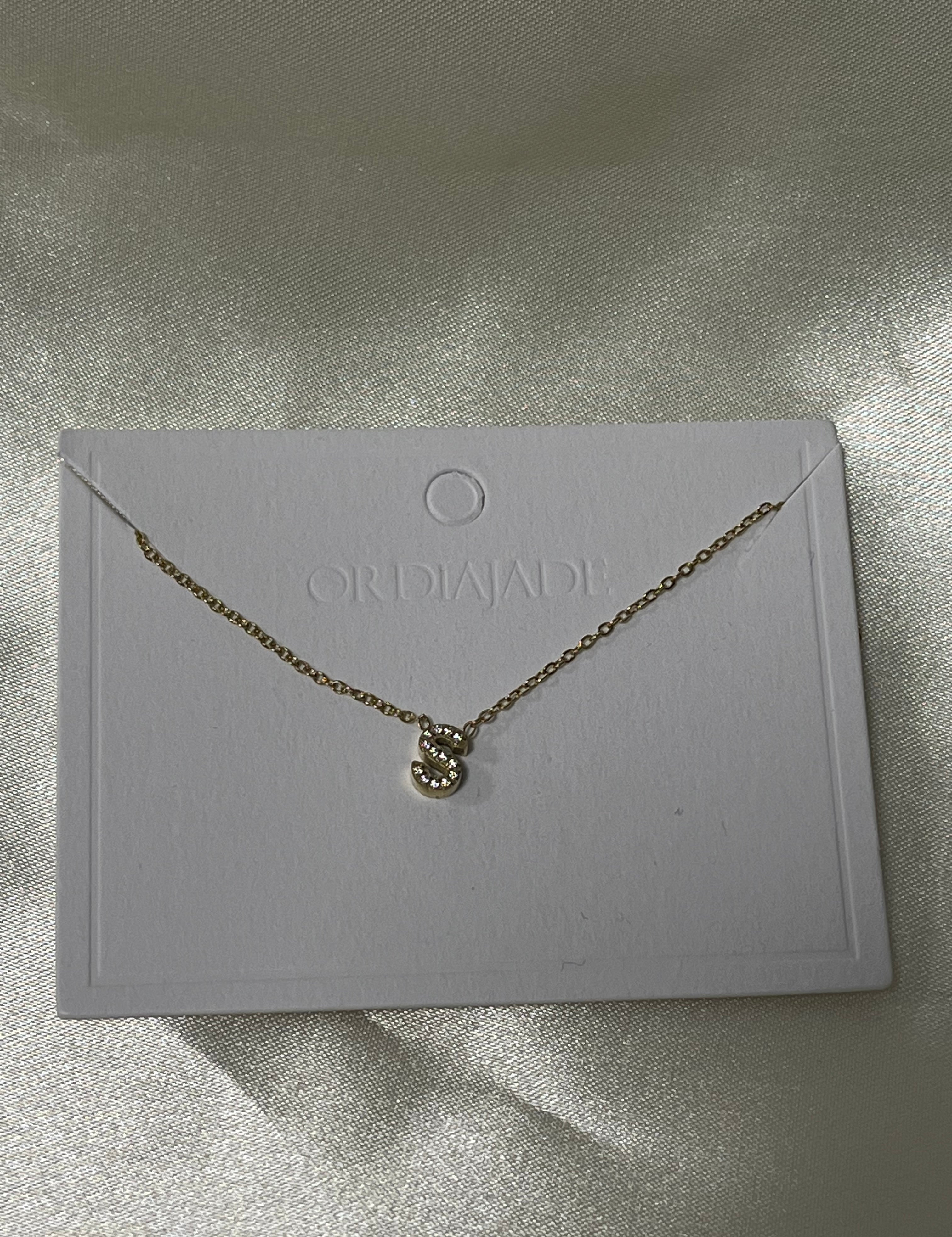 Collier Cuty doré à initiale S sertie de strass, sur sa carte de présentation - Ordiajade