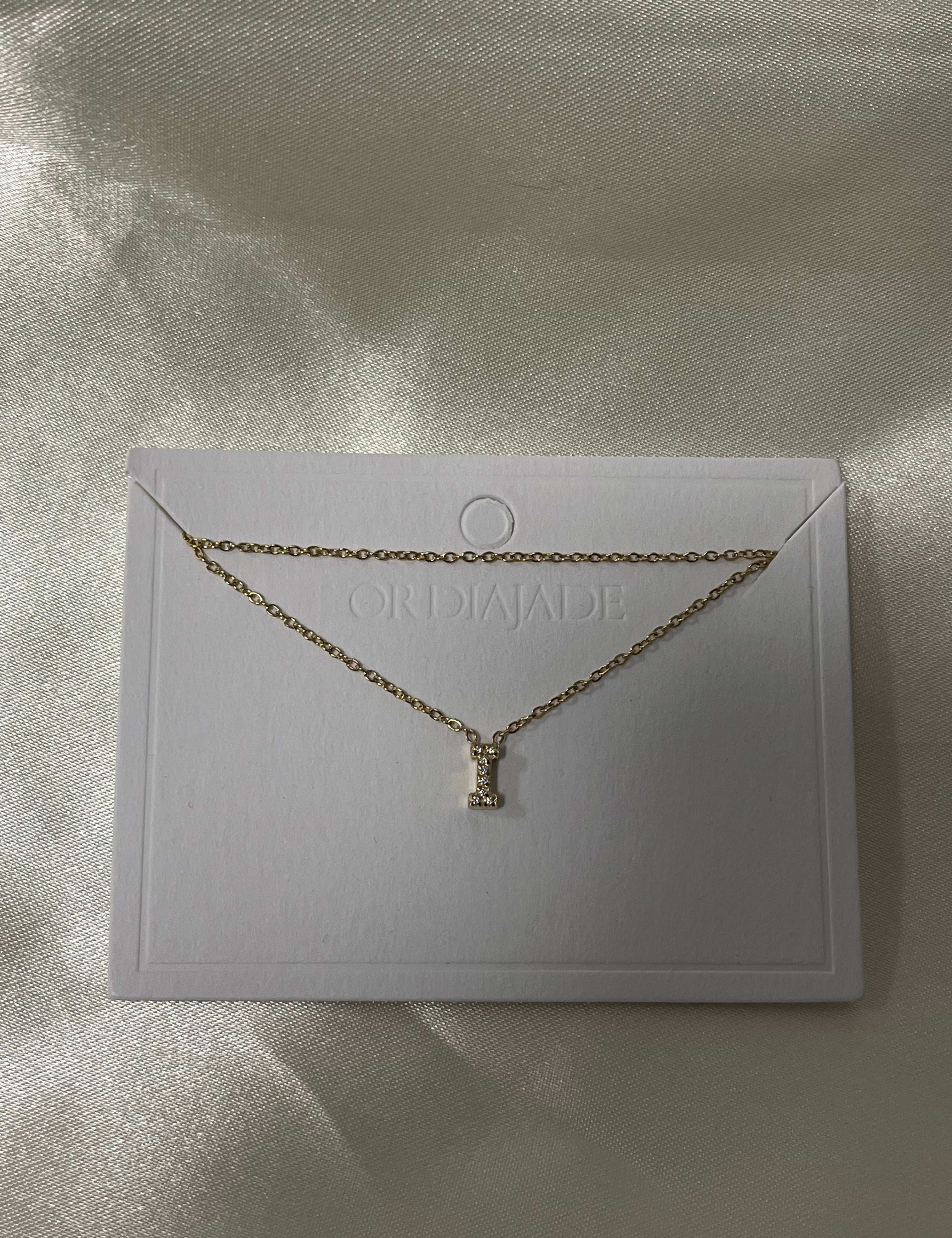 Collier Cuty doré à initiale I sertie de strass, sur sa carte de présentation - Ordiajade