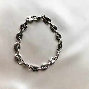 Bracelet Mouss argenté à gros maillons grain de café, posé sur un tissu blanc - Ordiajade